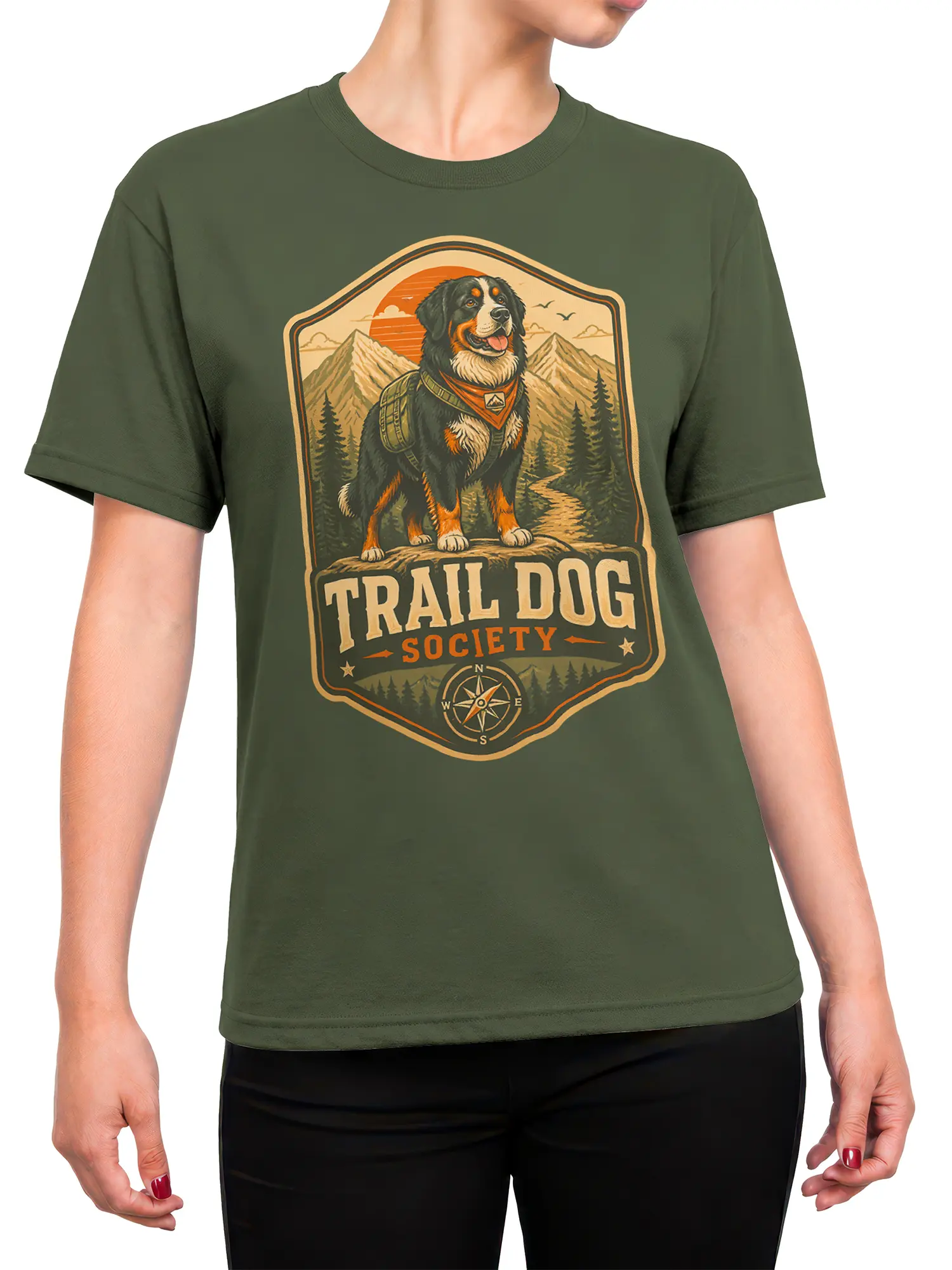 Woman wearing olive green trail dog society T-shirt with vintage hiking dog, mountains, and compass artwork