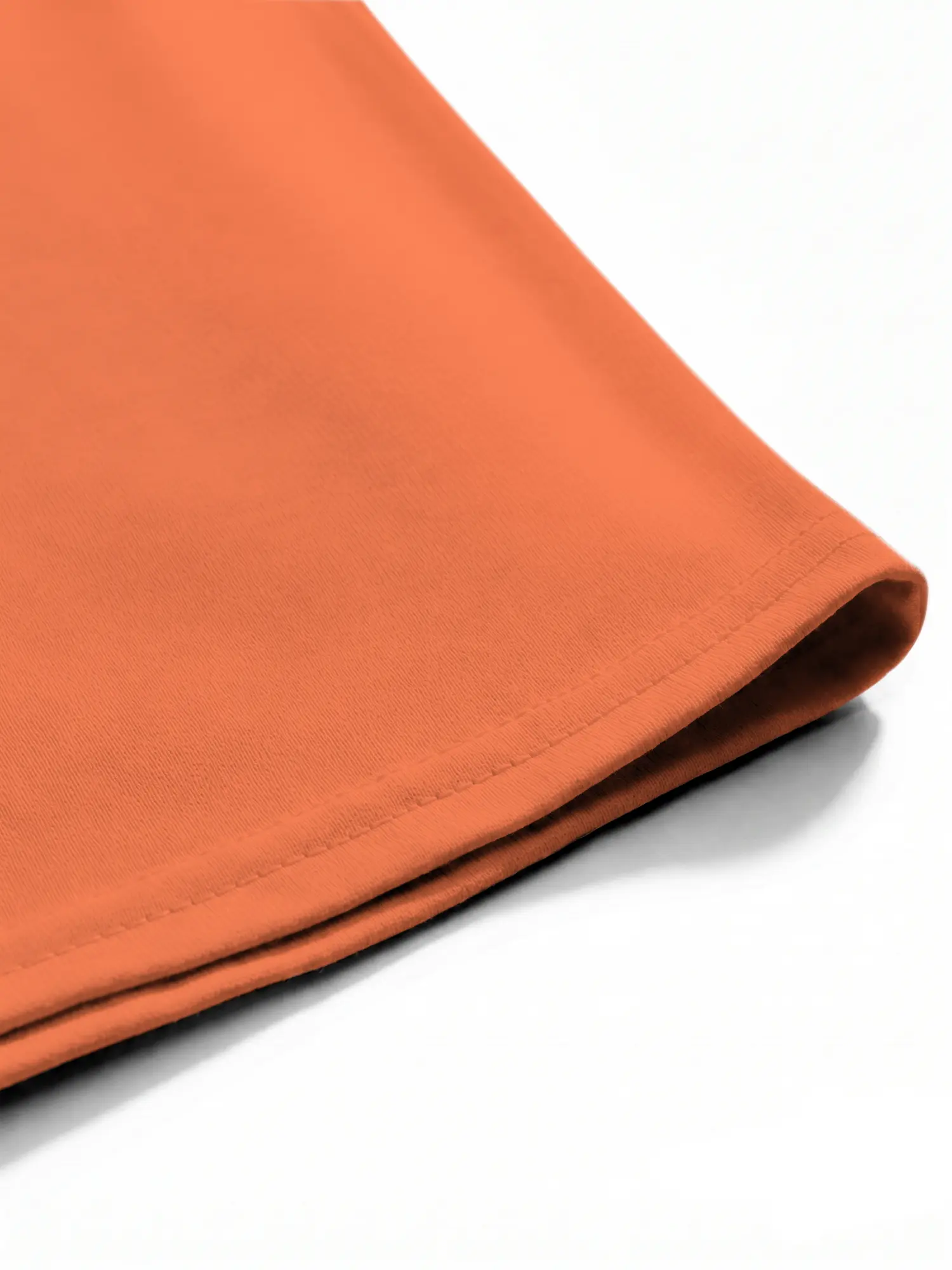 Close-up of hem stitching on the orange cotton t-shirt, showing durable seams and smooth fabric.