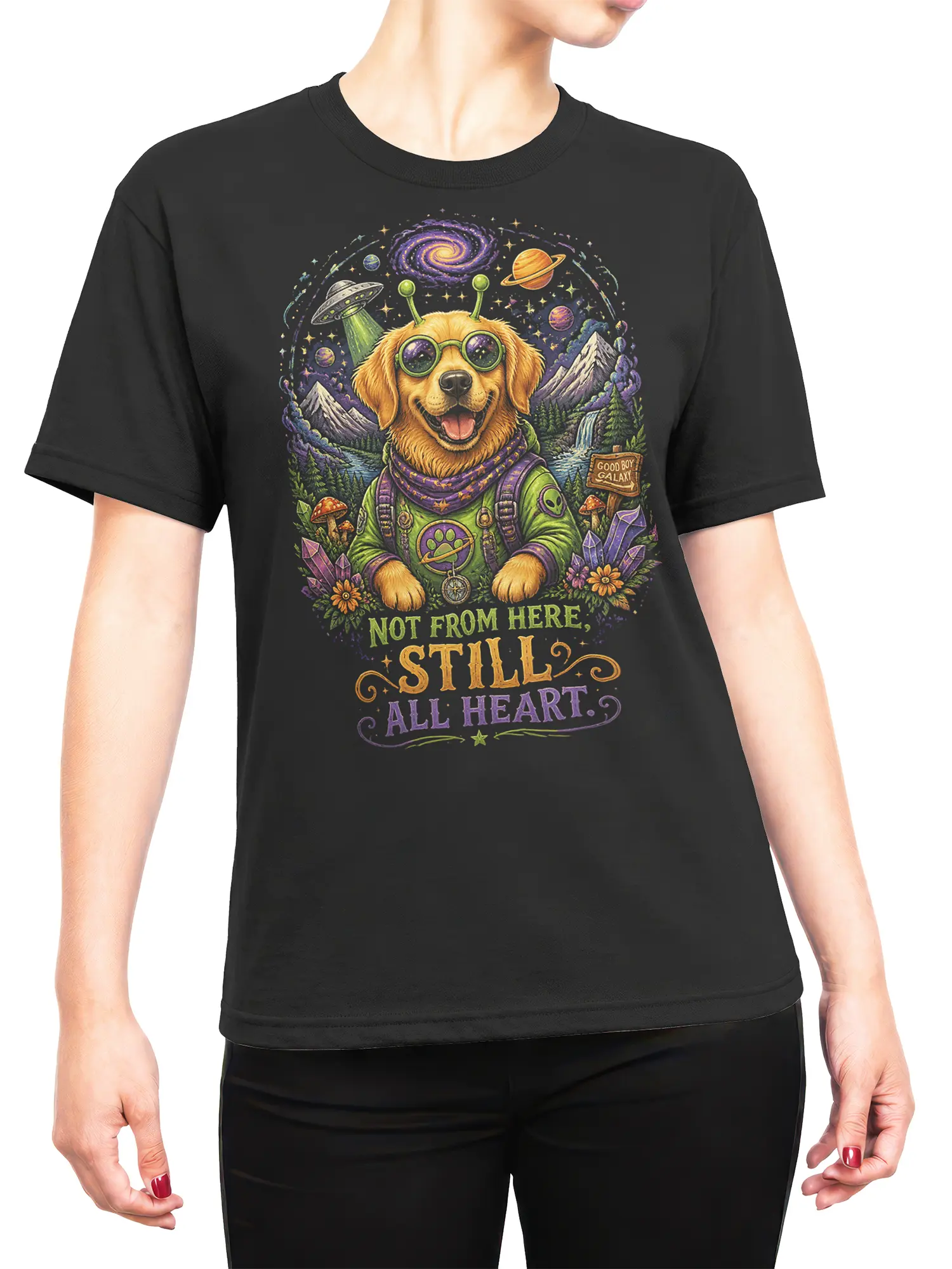 Woman wearing black alien golden retriever galaxy t-shirt with “Not From Here, Still All Heart” quote