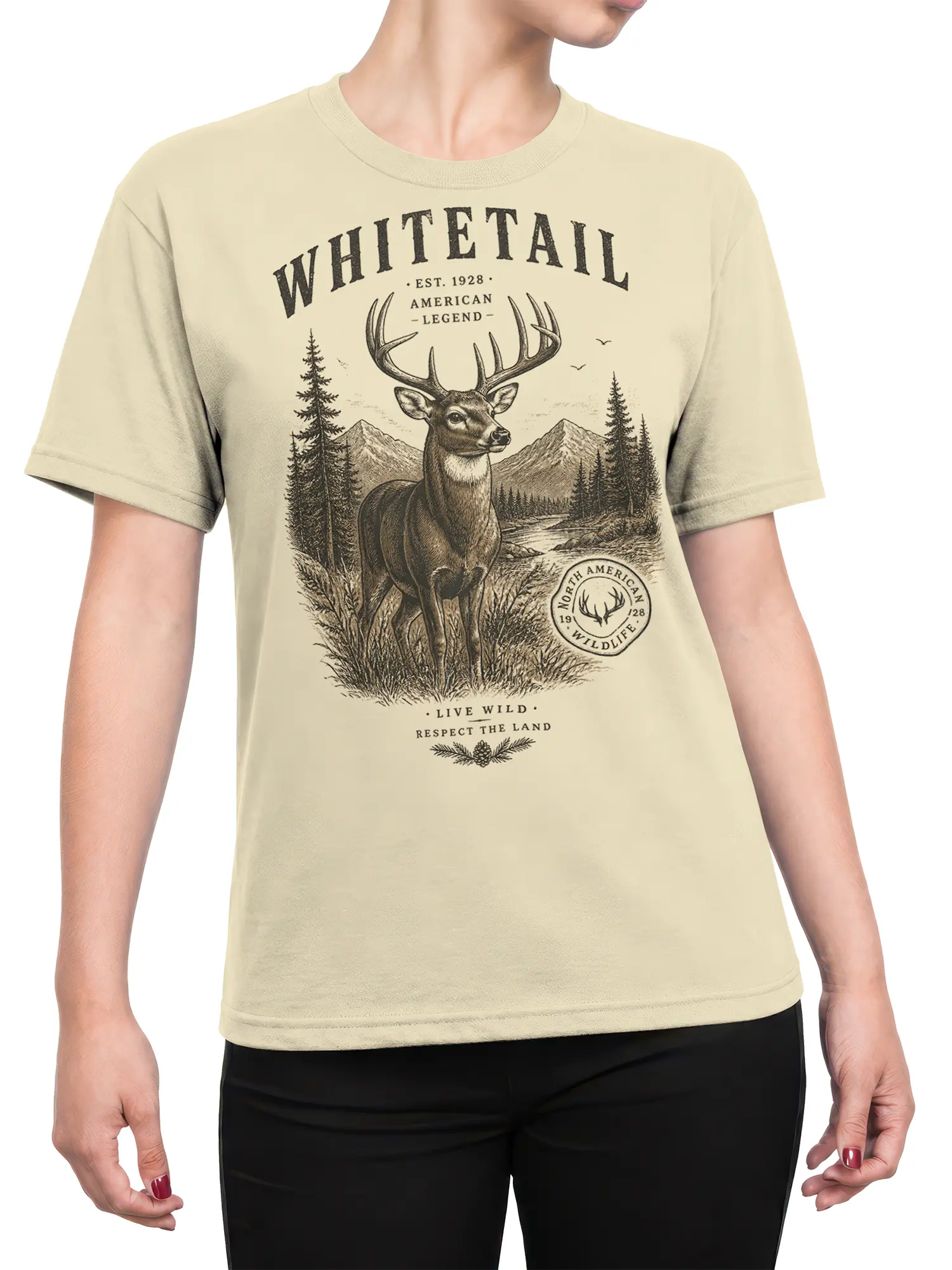 female model wearing beige whitetail deer wilderness graphic tee with forest and mountain scene