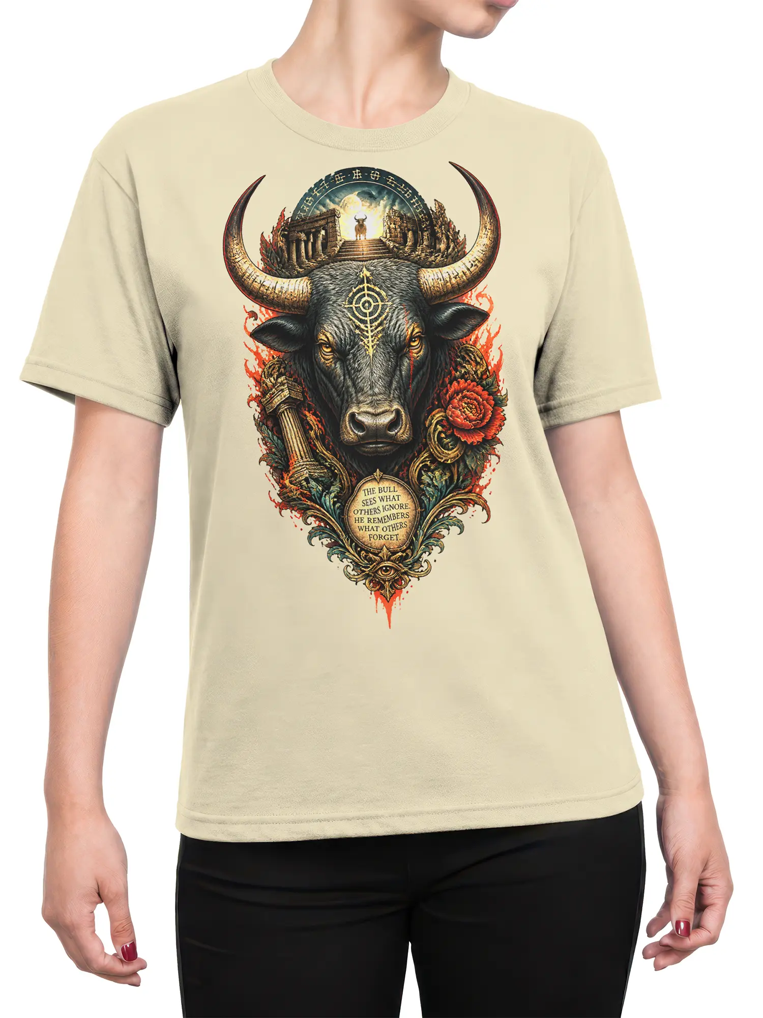 Female torso wearing beige T-shirt with horned bull, temple artwork, red flowers, and memory quote