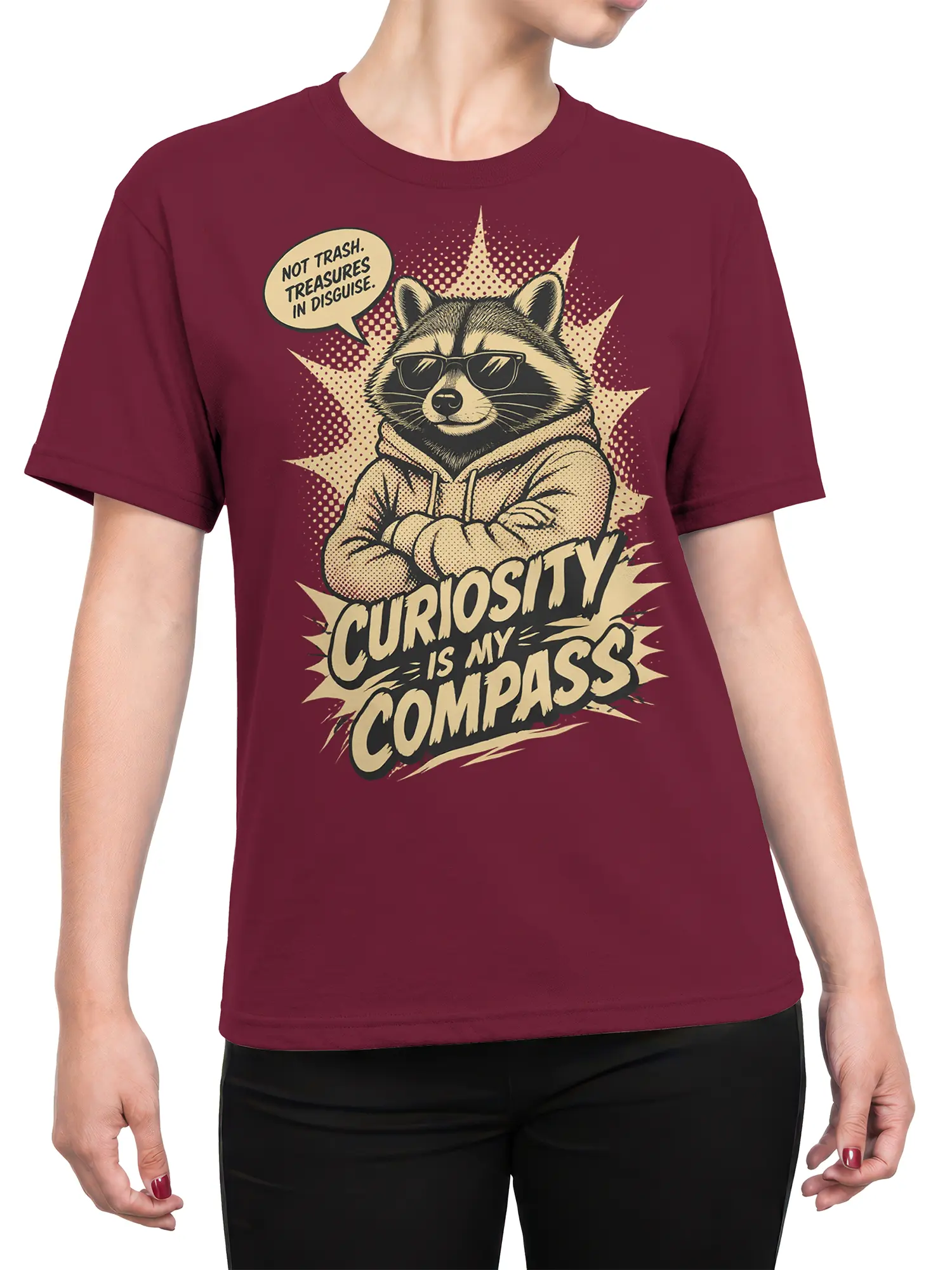Female torso wearing a burgundy raccoon T-shirt with retro comic art and “Curiosity Is My Compass” lettering