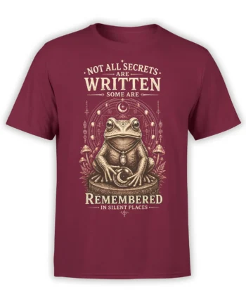 Mystical frog holding a moon crystal on a maroon shirt with mushrooms and celestial symbols