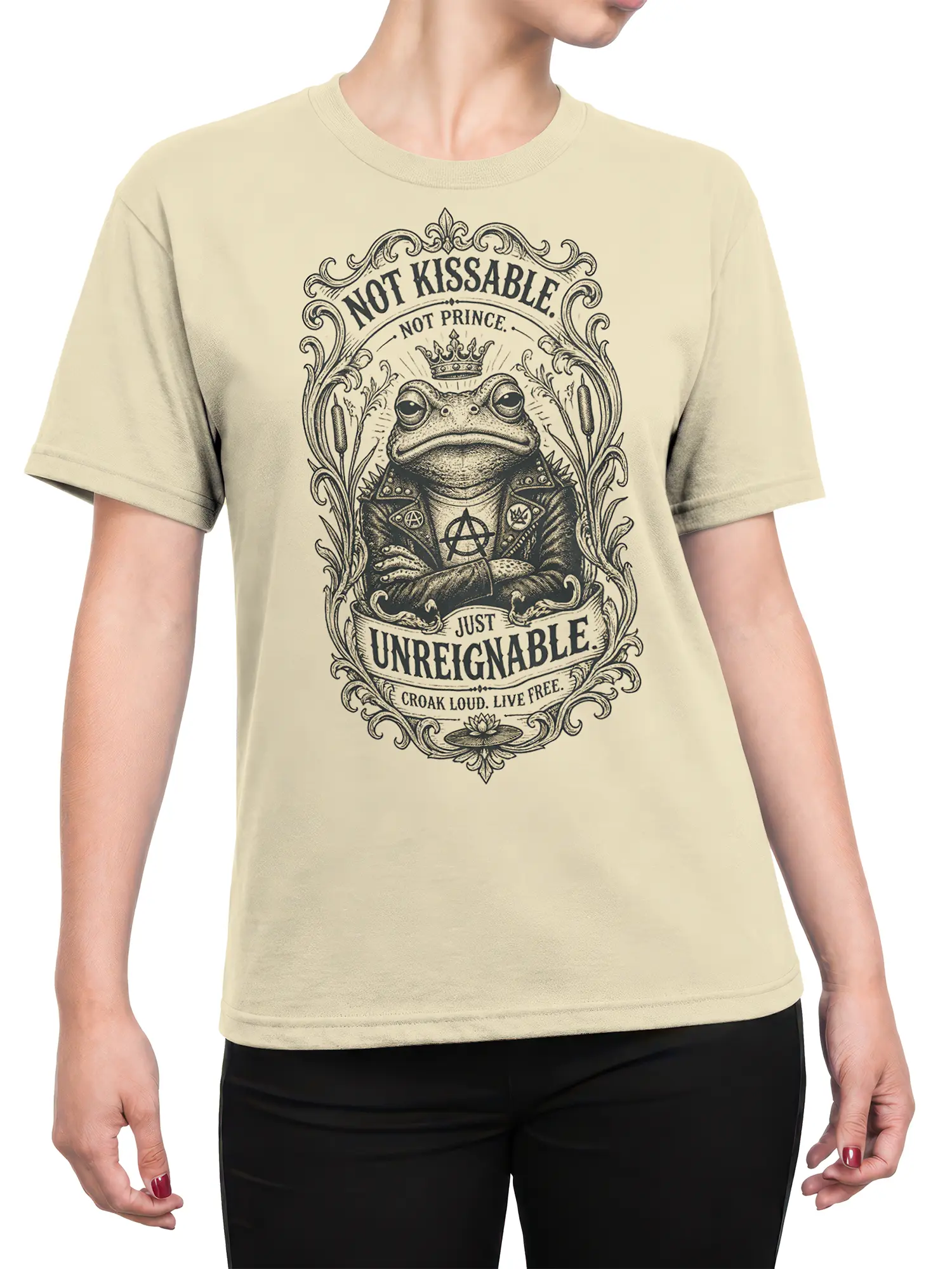 Female torso wearing a beige T-shirt with a detailed crowned punk frog graphic and vintage “Unreignable” lettering