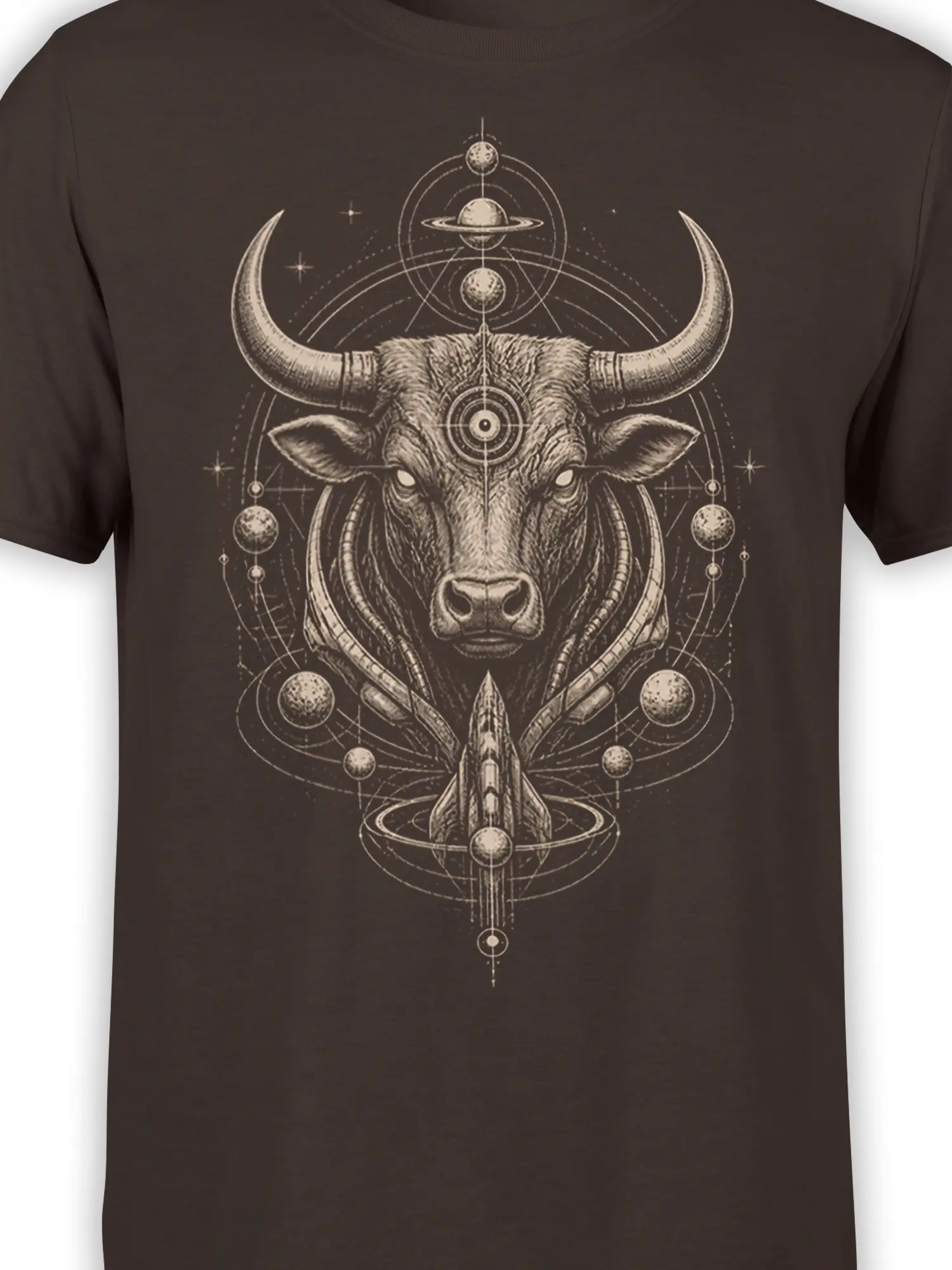 Close-up of celestial bull artwork with horns, planets, rocket, and fine vintage engraving details on a brown shirt