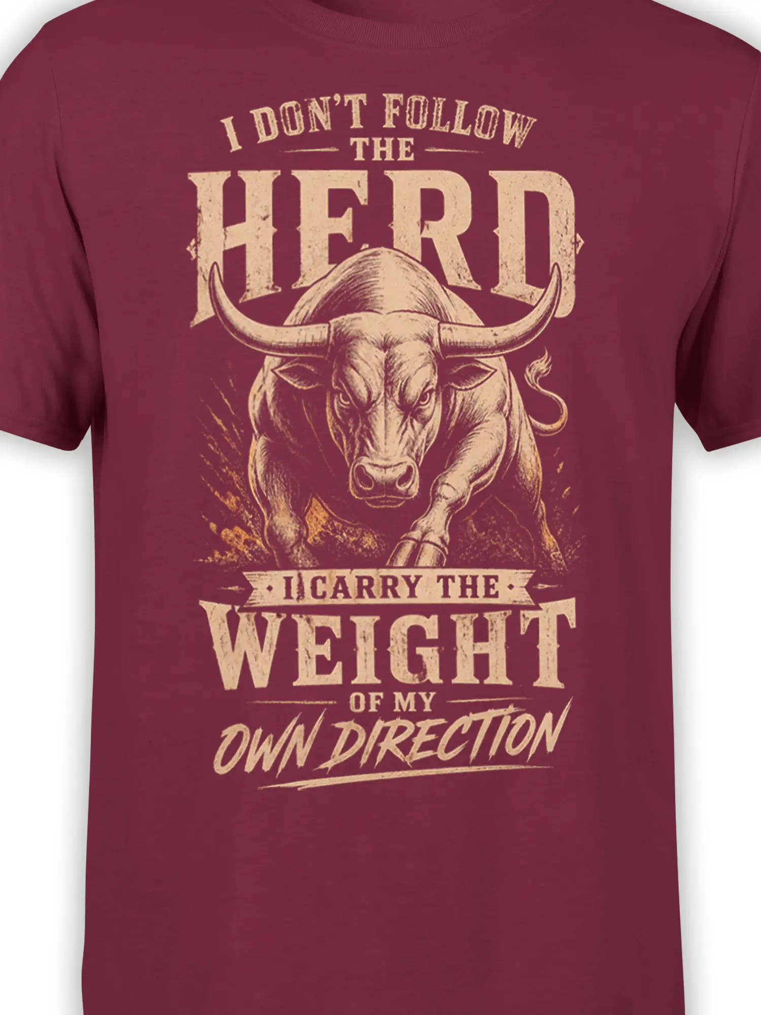 Close-up of charging bull artwork and distressed cream lettering on a burgundy T-shirt
