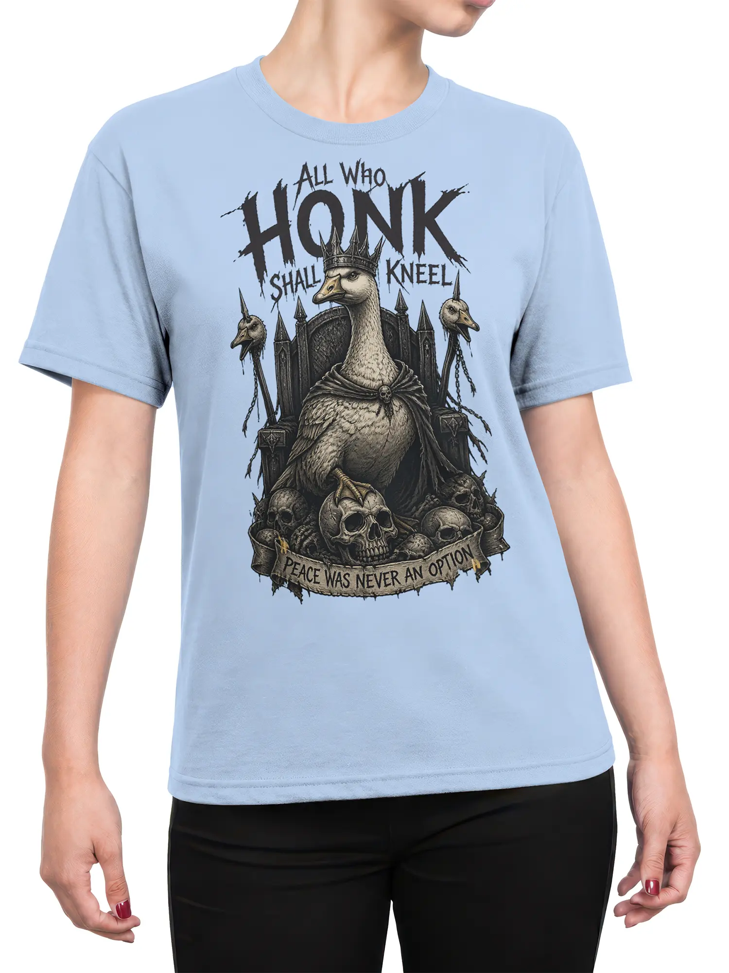 Female torso wearing a light blue crowned goose shirt with gothic skull artwork and bold All Who Honk Shall Kneel text