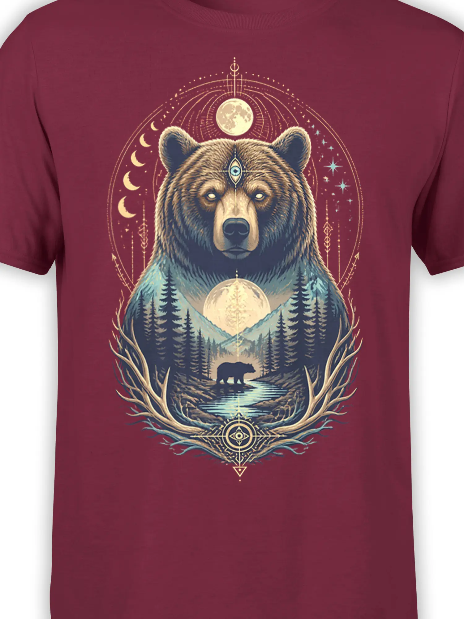 Close-up of mystical bear artwork with a forehead symbol, moon, stars, and forest details on burgundy fabric