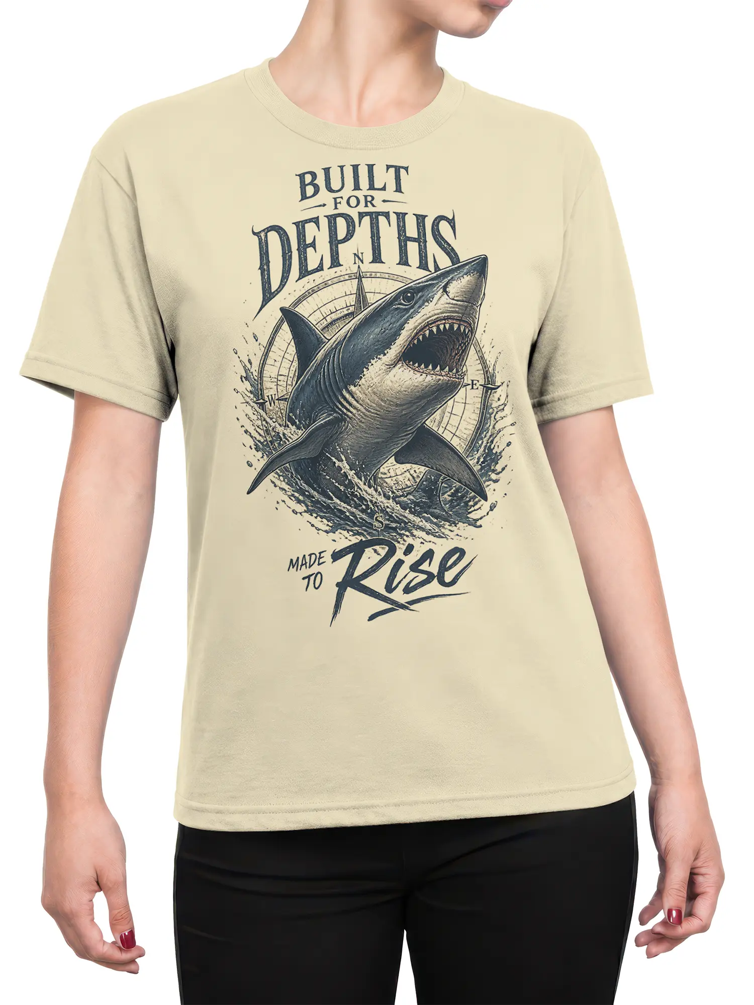 Female torso wearing a beige shark T-shirt with vintage nautical artwork and “Made to Rise” text