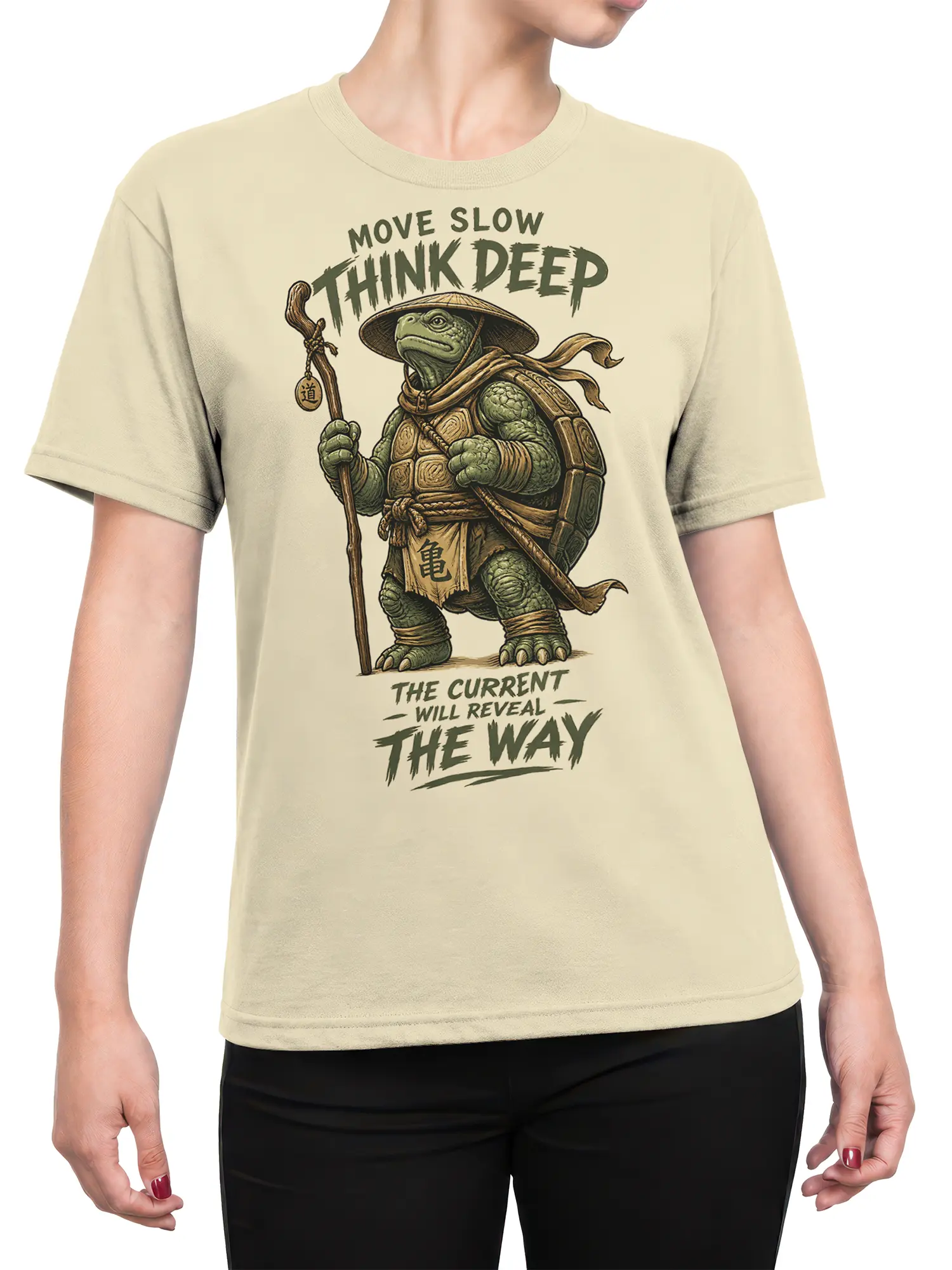 Female torso wearing a beige T-shirt with a thoughtful turtle traveler and slow-living artwork