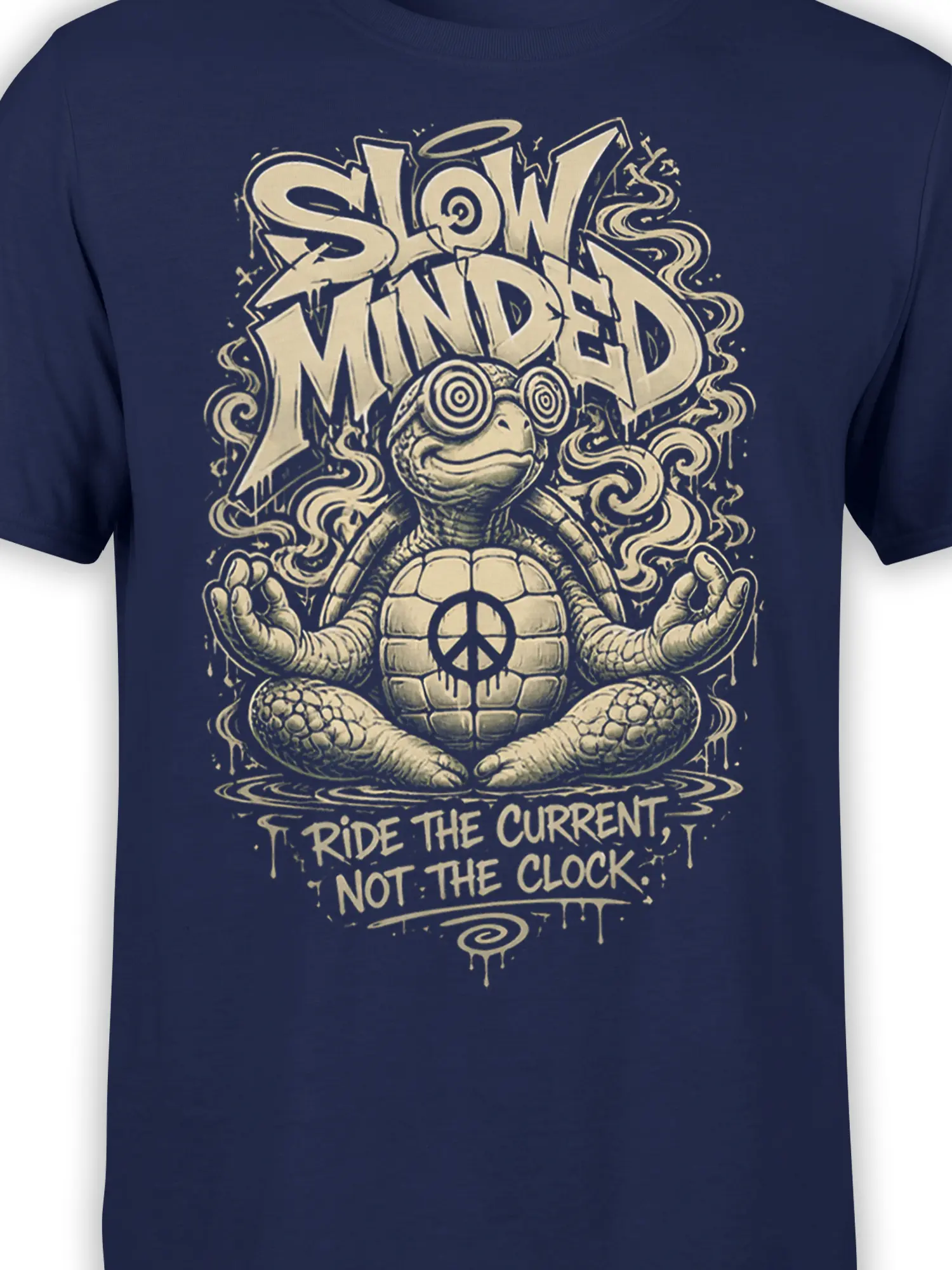 Close-up of meditating turtle artwork, peace symbol, swirling waves, and cream text on a navy T-shirt