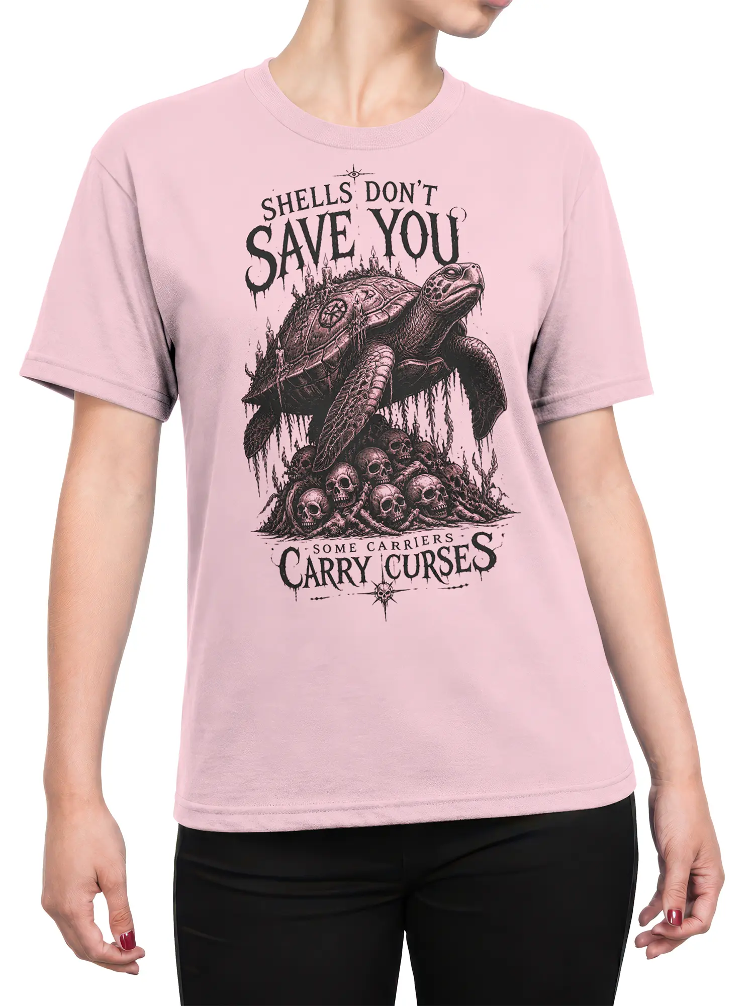 Female torso wearing a pink T-shirt with a gothic turtle, skulls, candles, and dark fantasy lettering
