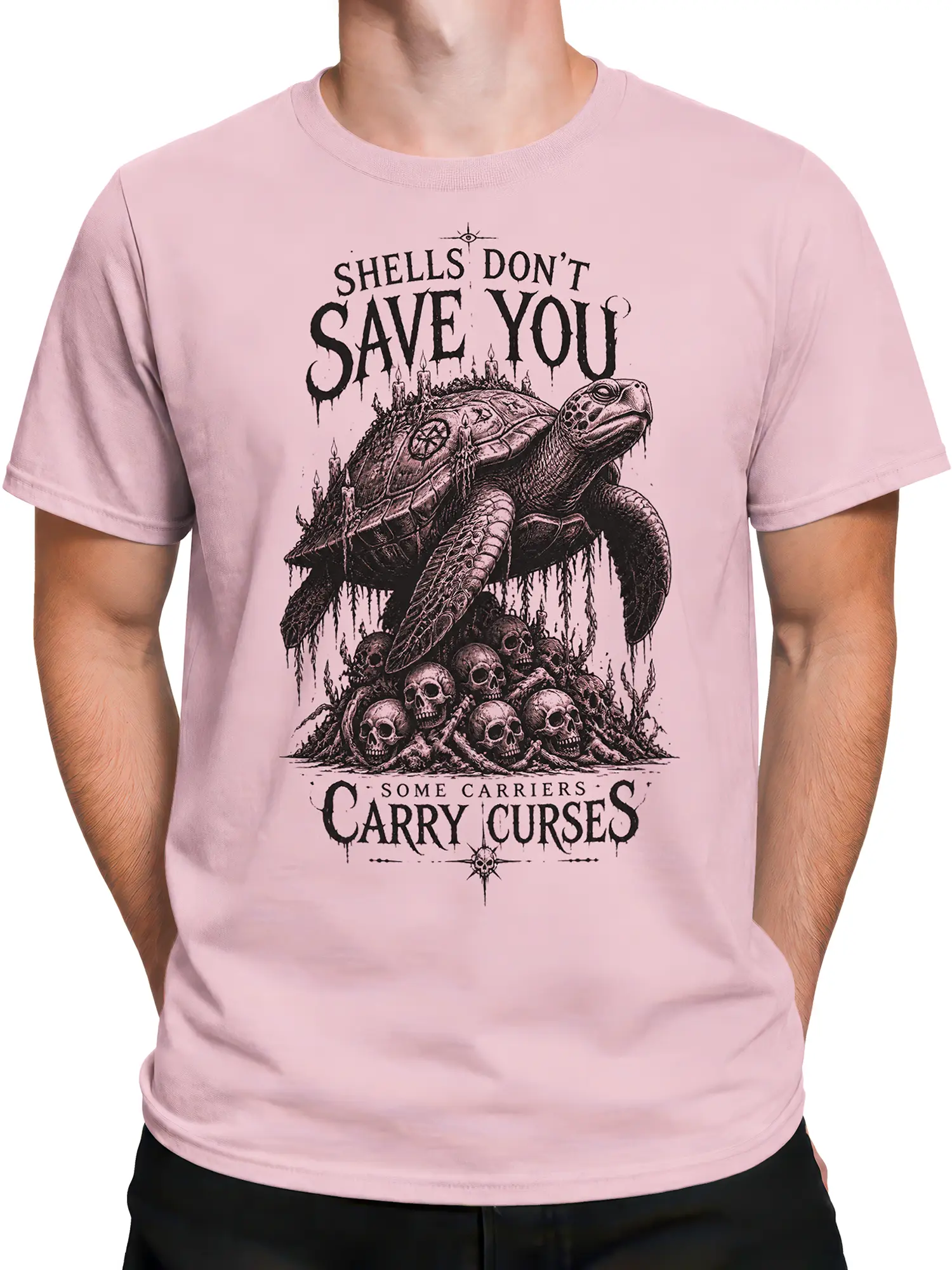 Male torso wearing a pink T-shirt with a black gothic turtle, skulls, candles, and cursed shell artwork