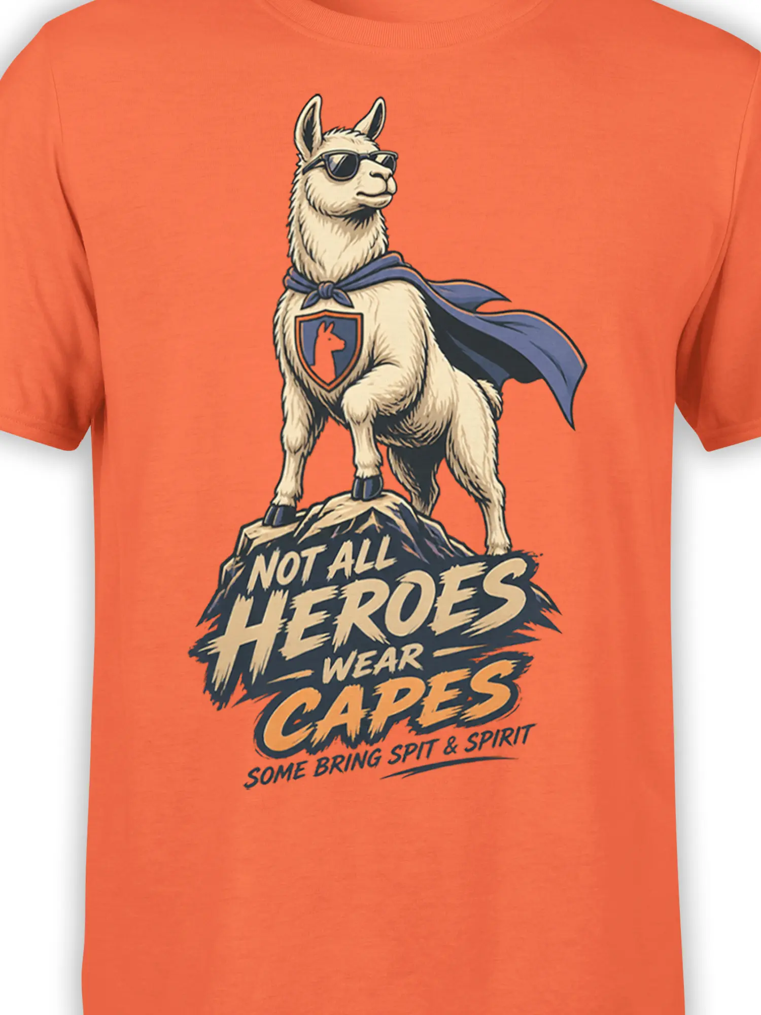 Close-up of superhero llama artwork with sunglasses, cape, shield emblem, and mountain details on an orange T-shirt