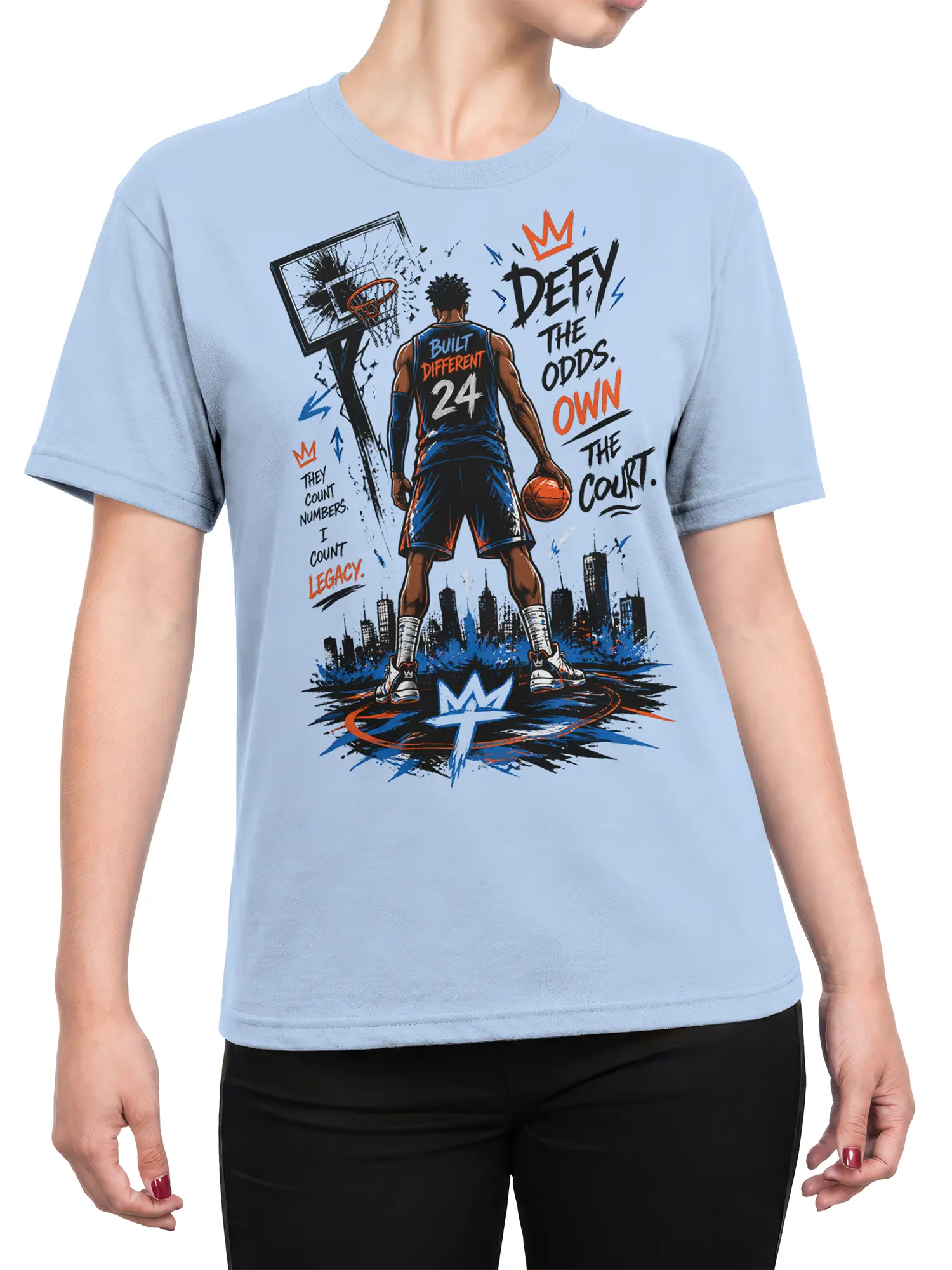 Female torso wearing a light blue basketball T-shirt with bold player artwork, city skyline, and Defy the Odds text