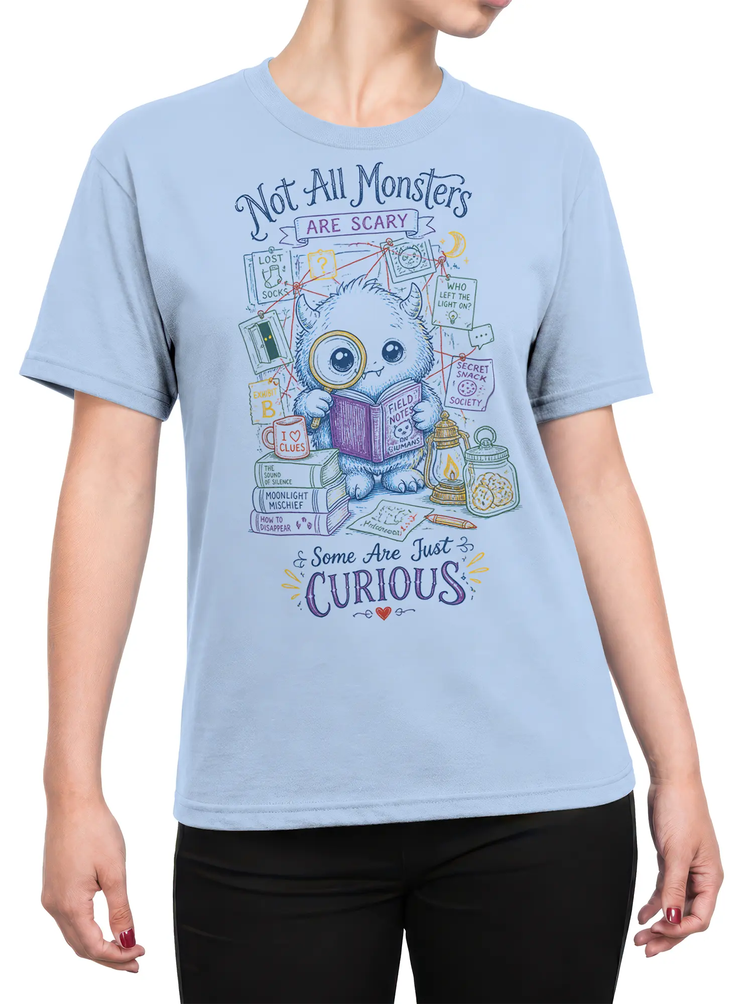 Female torso wearing a light blue T-shirt with a curious monster detective and mystery clue artwork