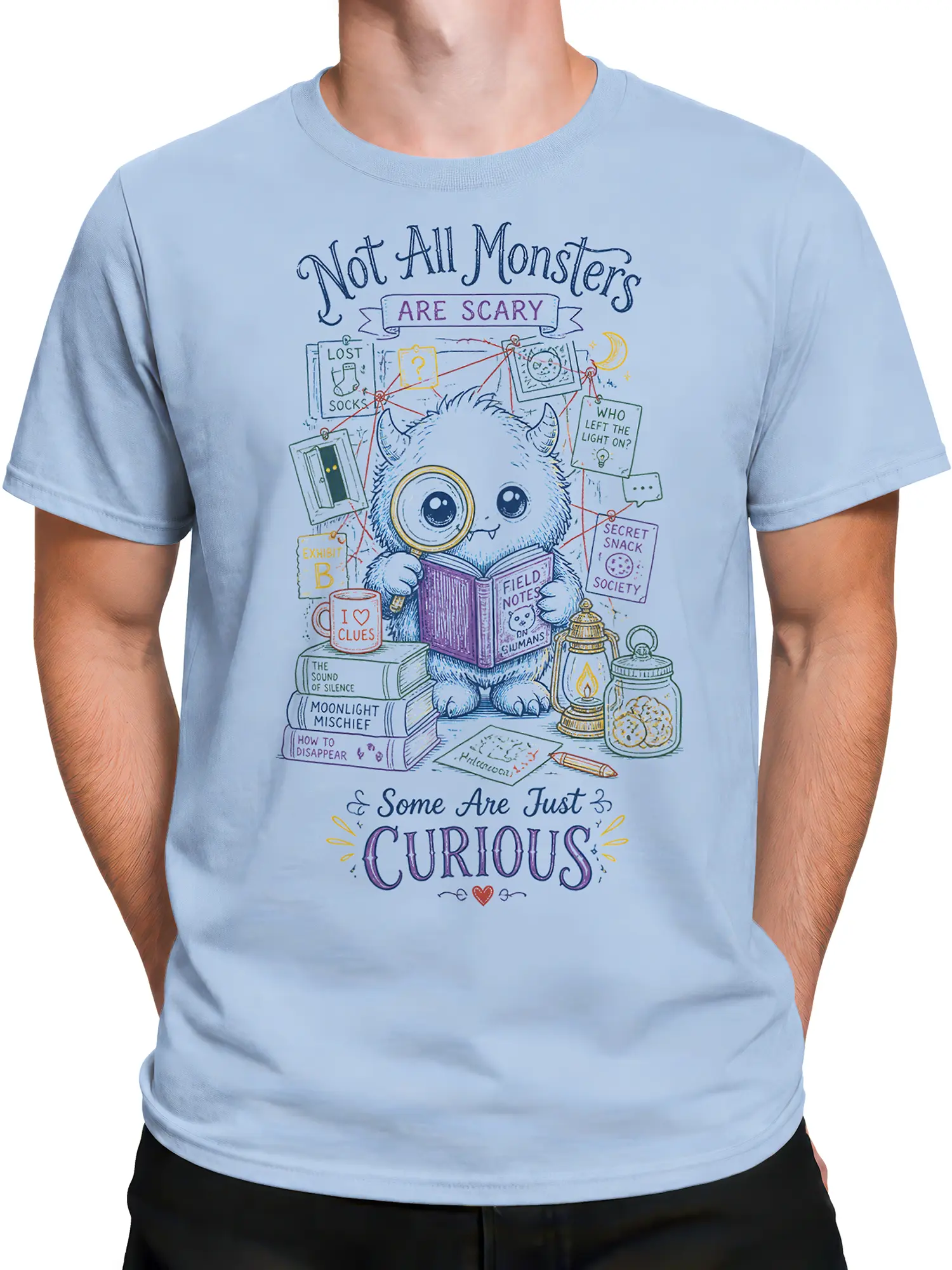 Male torso wearing a light blue T-shirt with curious monster detective graphic and colorful mystery clues