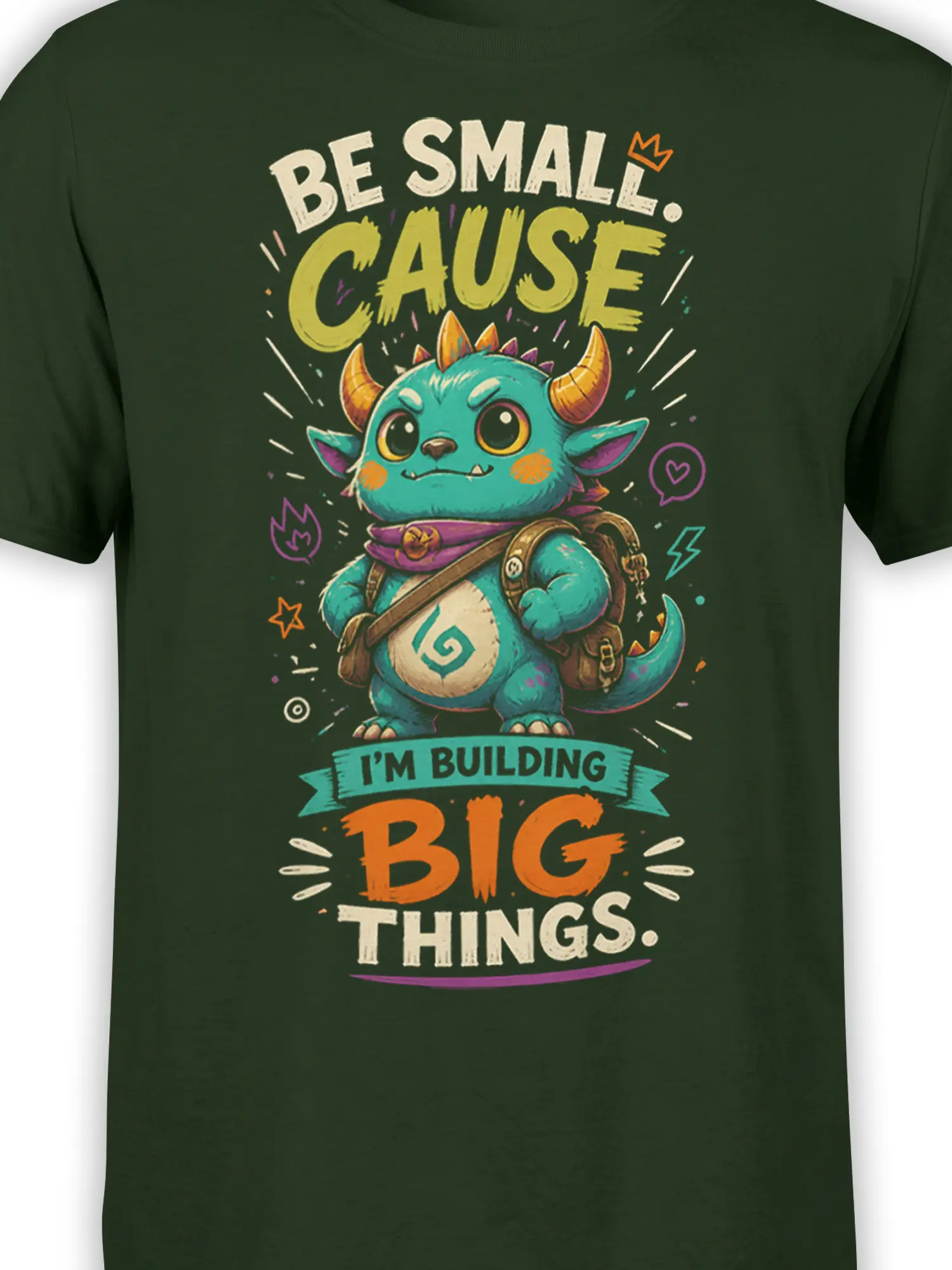 Close-up of turquoise horned fantasy creature artwork and bold motivational text on a dark green T-shirt