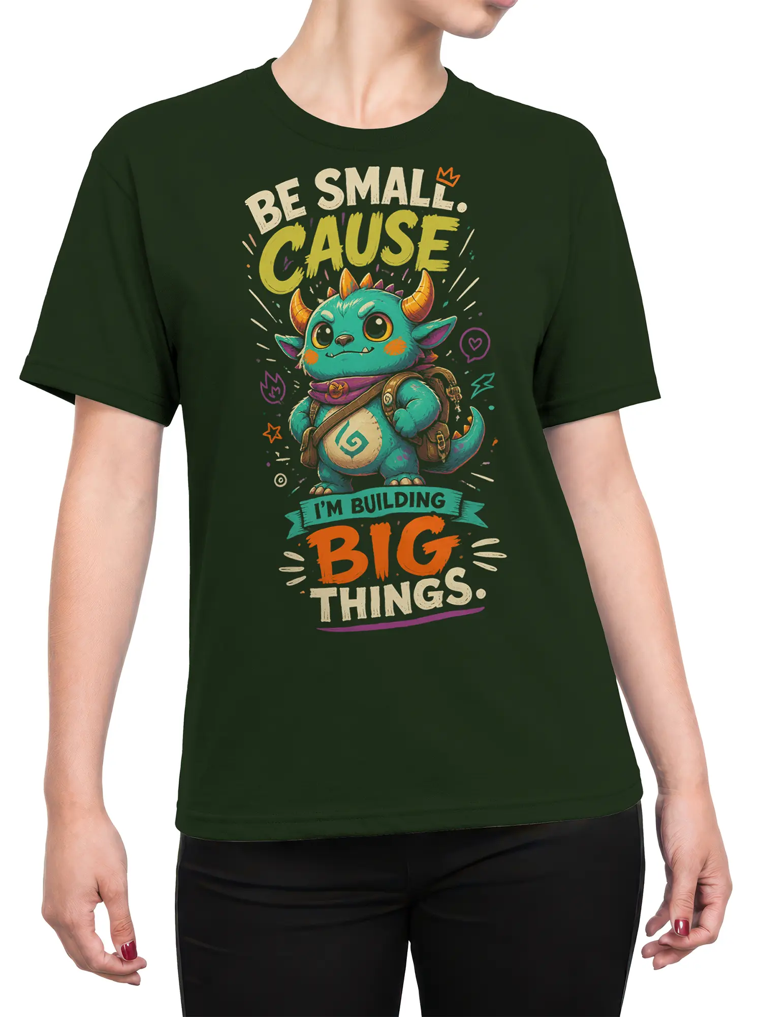Female torso wearing a dark green fantasy T-shirt with a turquoise horned creature and colorful “Big Things” design