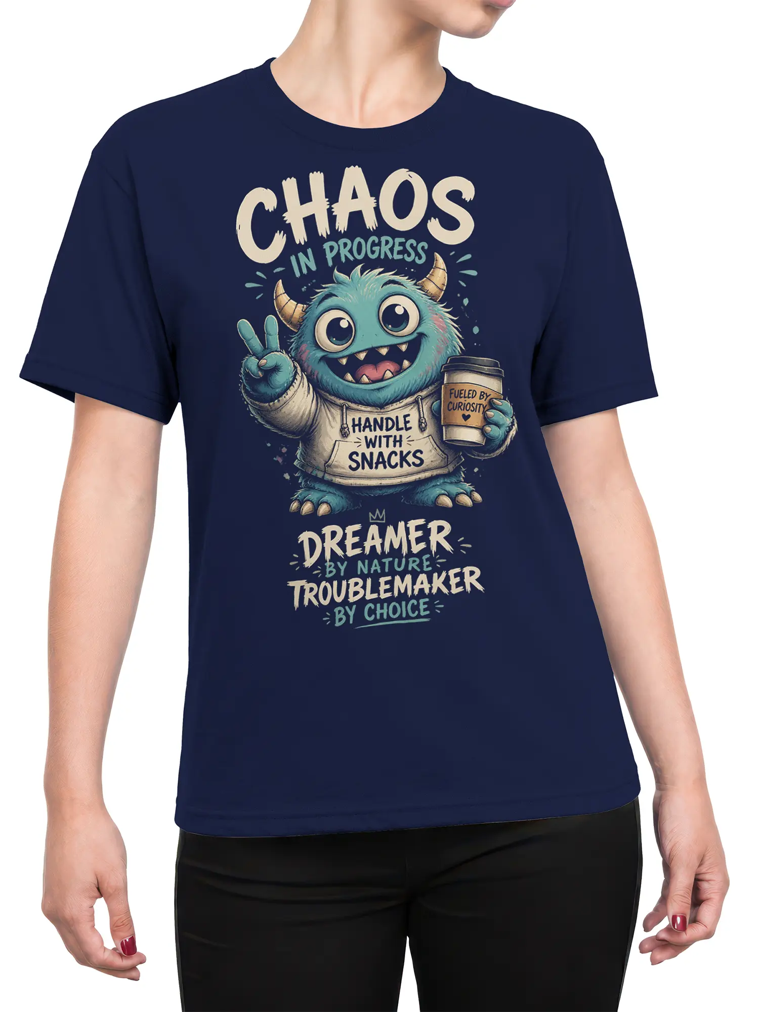 Female torso wearing navy monster T-shirt with curious creature, coffee cup, and Dreamer Troublemaker design