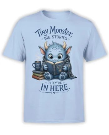 Light blue T-shirt with a blue horned monster reading a book beside coffee and stacked books