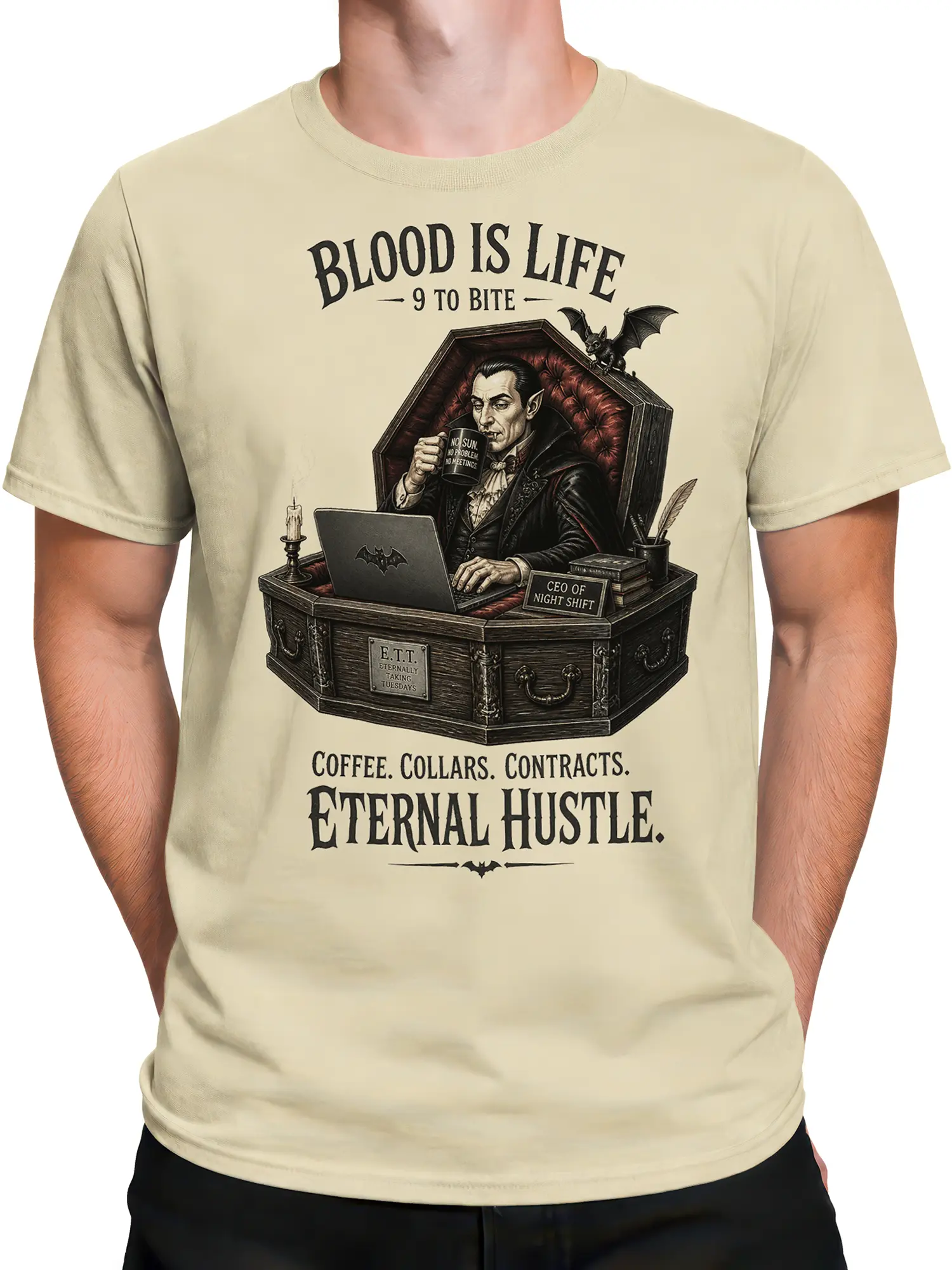 Male torso wearing a beige vampire T-shirt with coffee, coffin desk artwork, and eternal hustle lettering