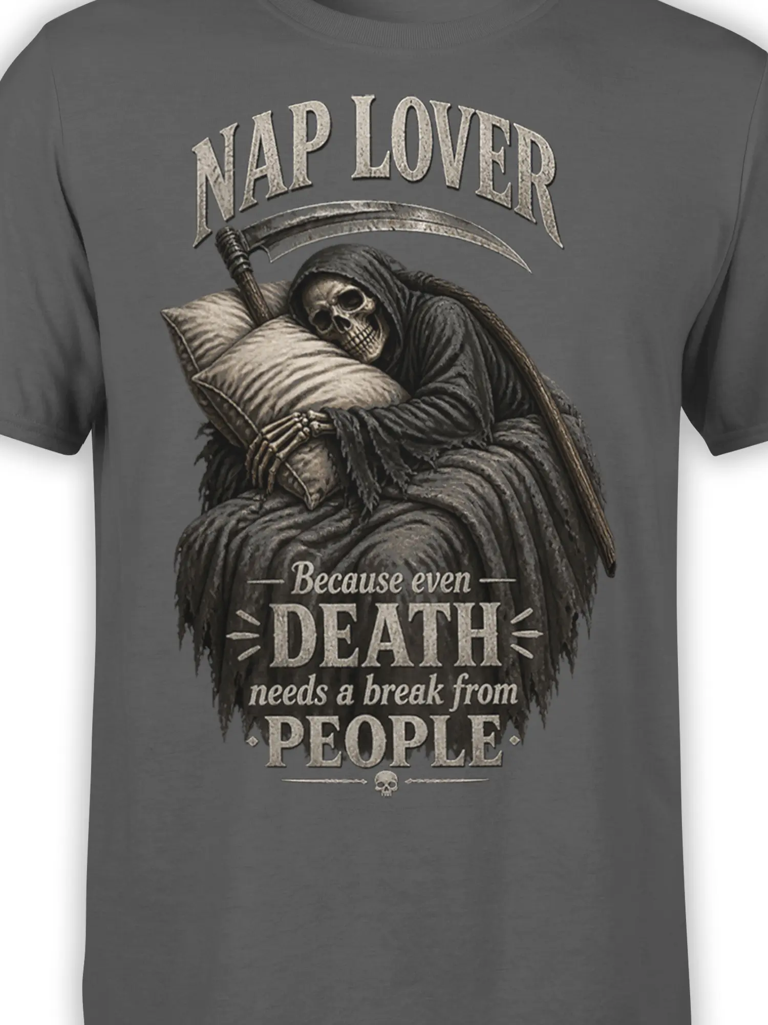 Close-up of sleeping Grim Reaper artwork with pillow, scythe, skull details, and distressed lettering on gray fabric