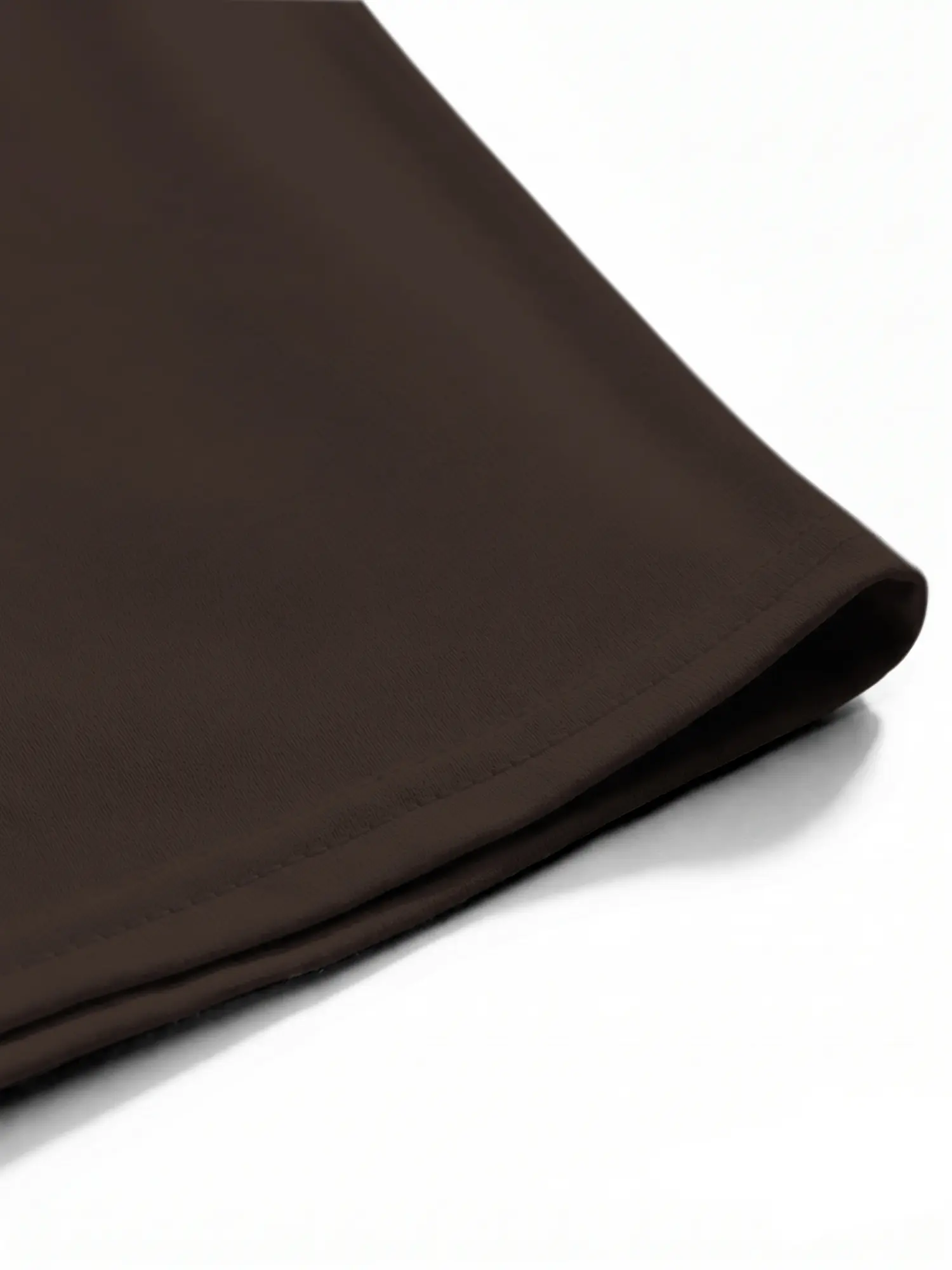 Brown cotton T-shirt hem and stitching close-up showing neat construction and smooth fabric