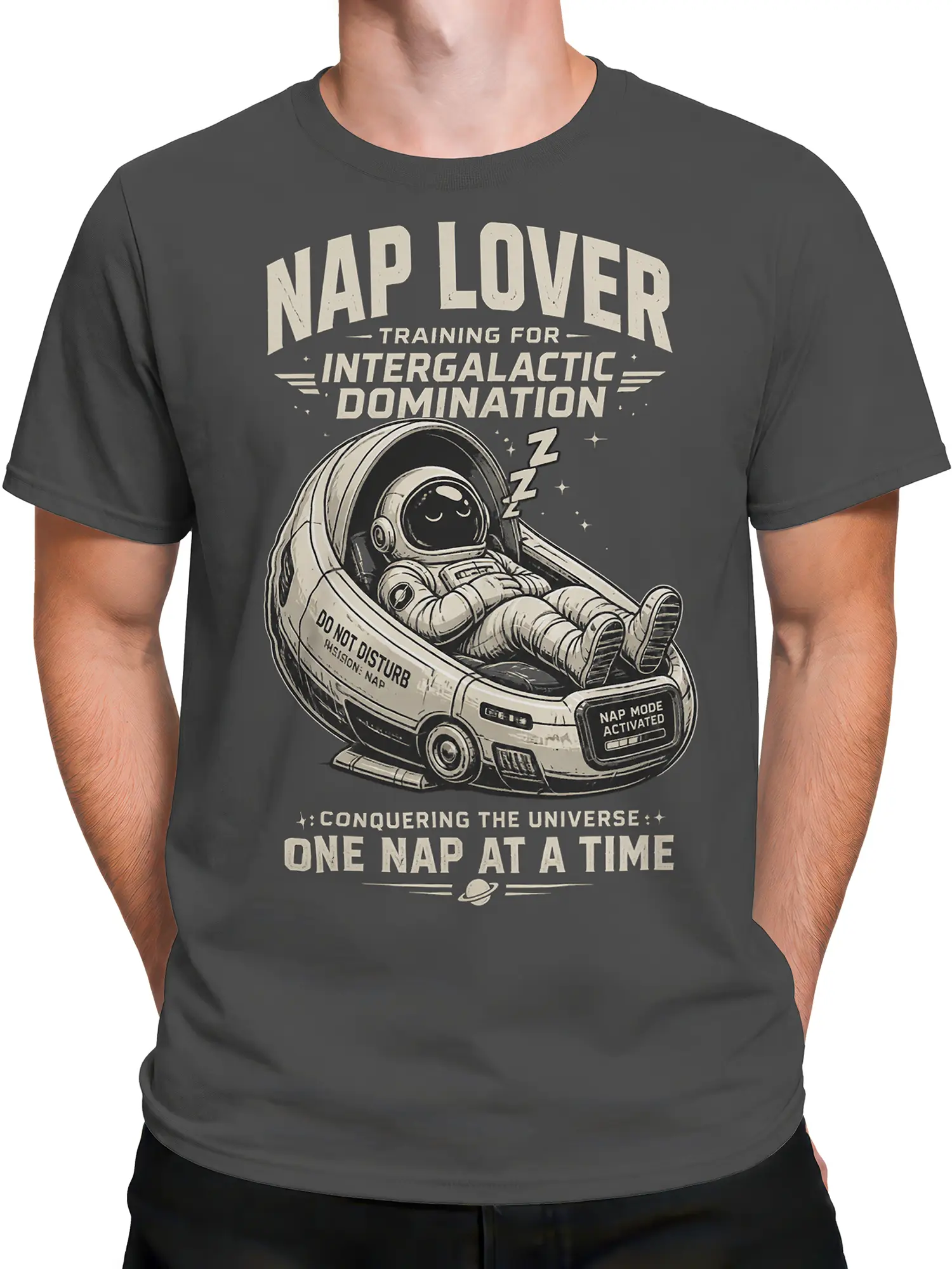 Male torso wearing gray astronaut T-shirt with sleeping astronaut and “Conquering the Universe” text