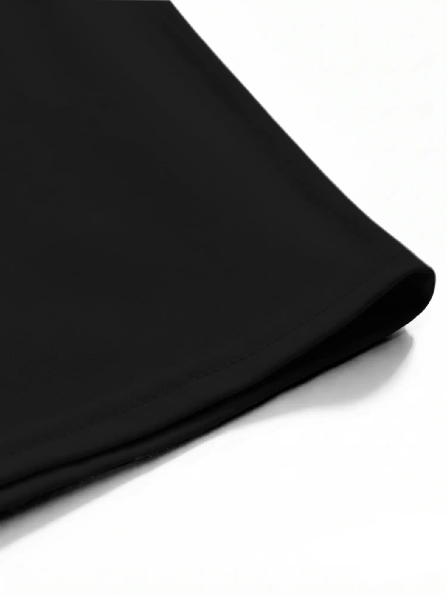 Black cotton shirt hem and stitching shown in a detailed close-up product view