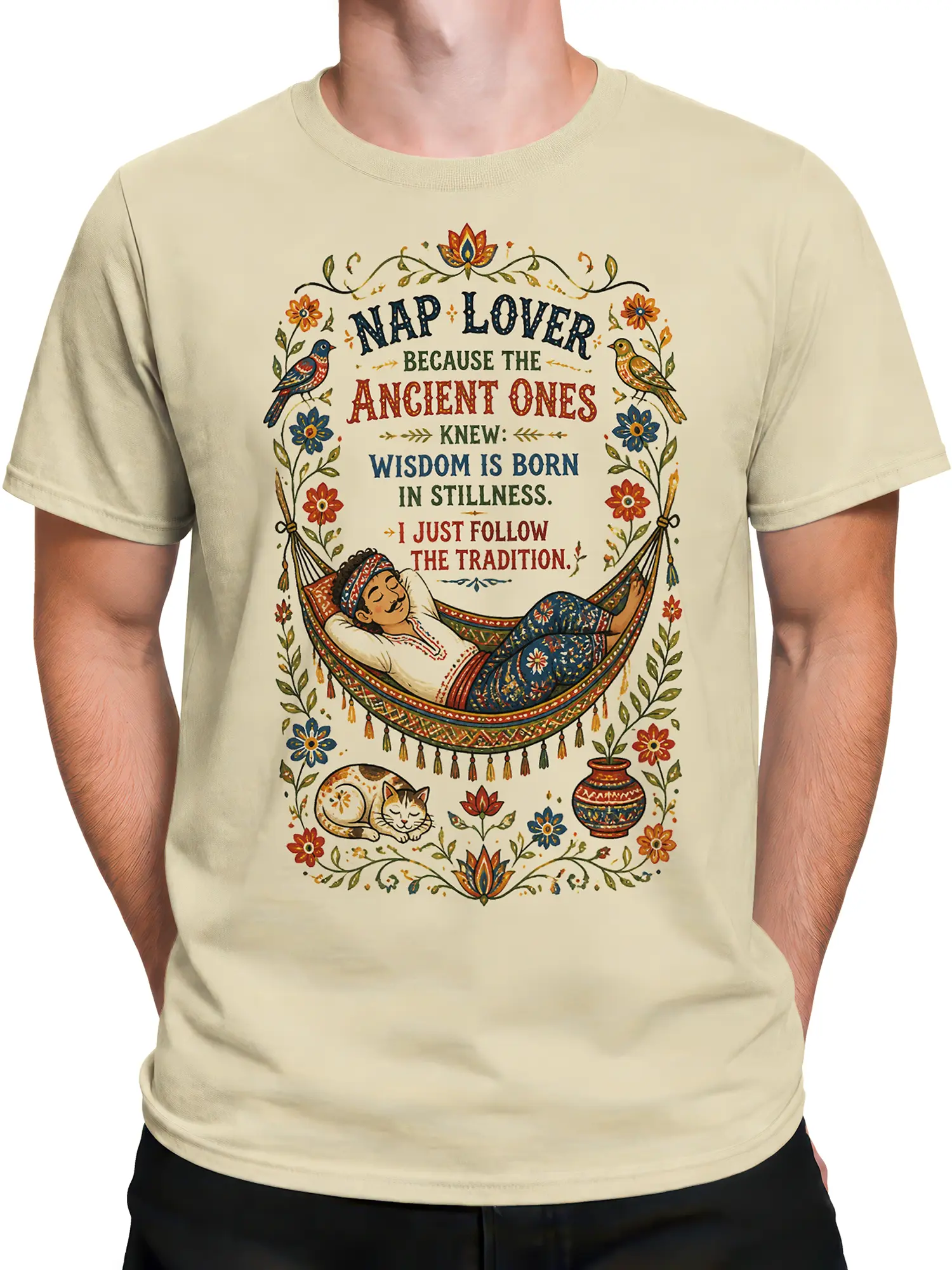 Male torso wearing a beige cat T-shirt with a vintage hammock illustration, sleeping cat, flowers, birds, and nap quote