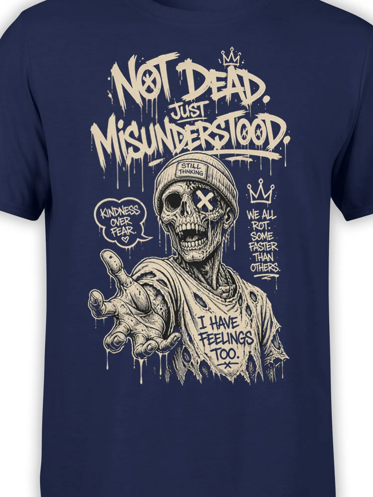 Close-up of cream zombie skull artwork, crown, beanie, and dripping text on a navy graphic tee