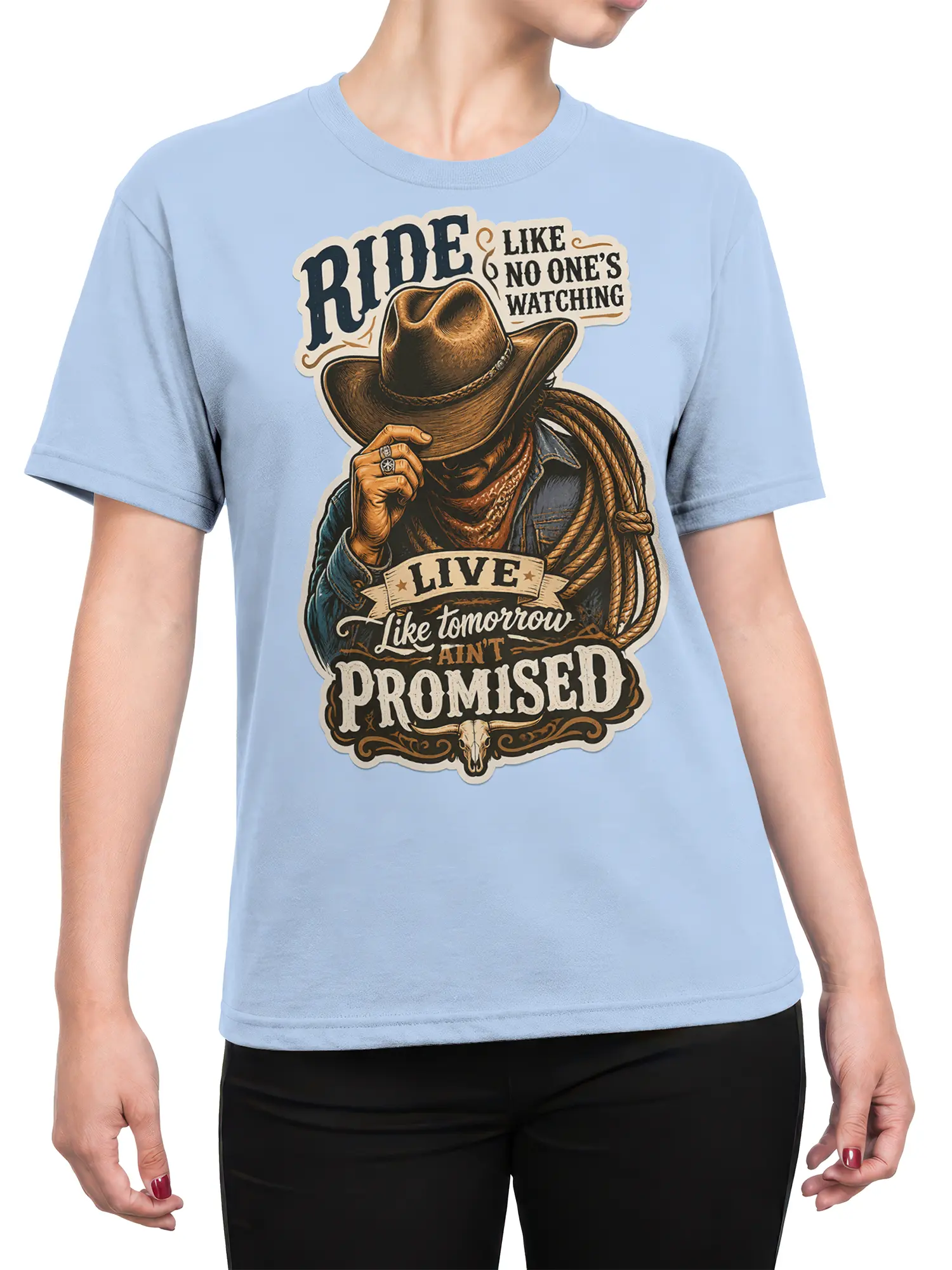 Female torso wearing a light blue cowboy T-shirt with rider, rope, skull, and vintage western lettering