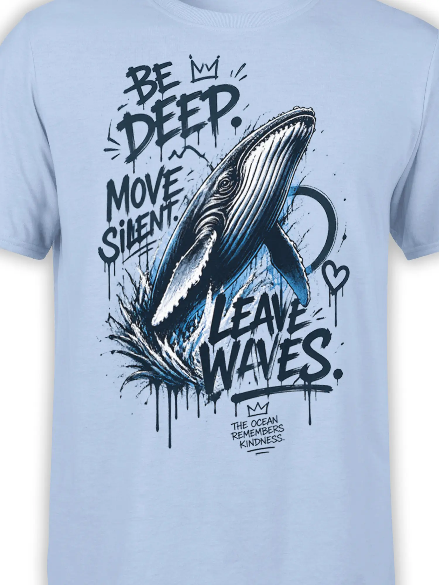 Close-up of whale, crashing waves, and bold ocean message printed on a light blue graphic T-shirt