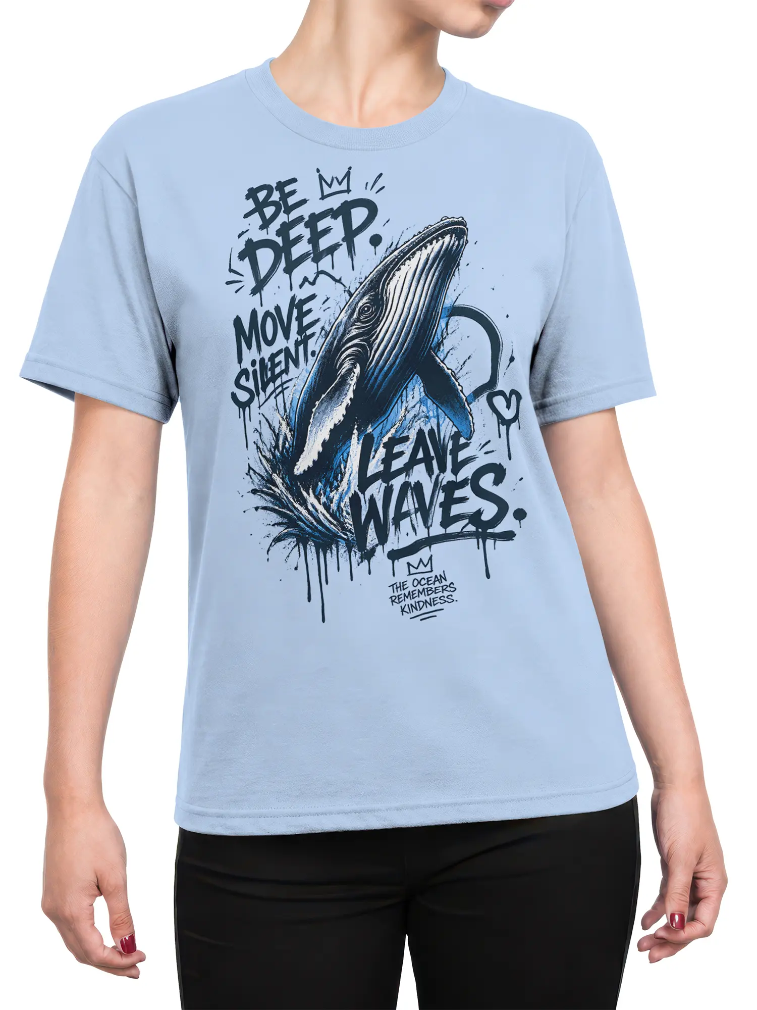 Female torso wearing a light blue whale graphic tee with bold waves and a quiet ocean message