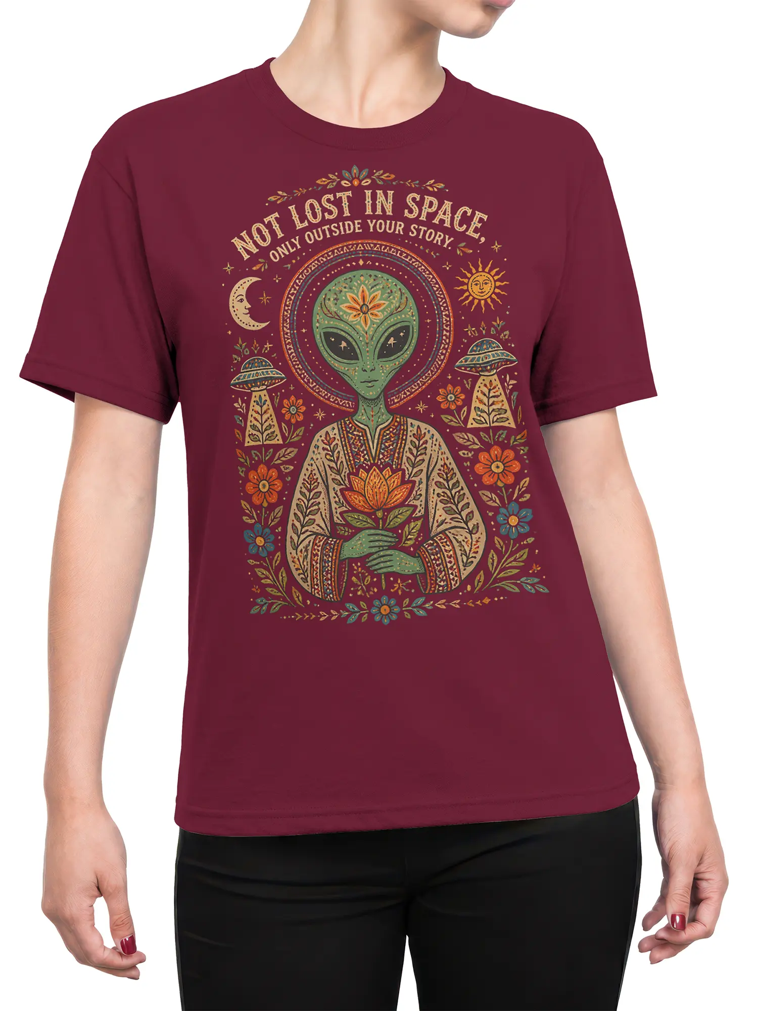Female torso wearing a maroon alien T-shirt with a lotus-holding alien, celestial symbols, flowers, UFOs, and quote
