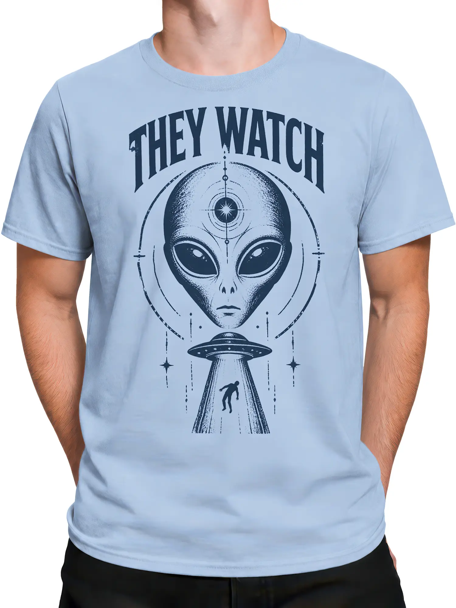Male torso wearing a light blue UFO T-shirt with a watchful alien, flying saucer beam, stars, and retro “THEY WATCH” print