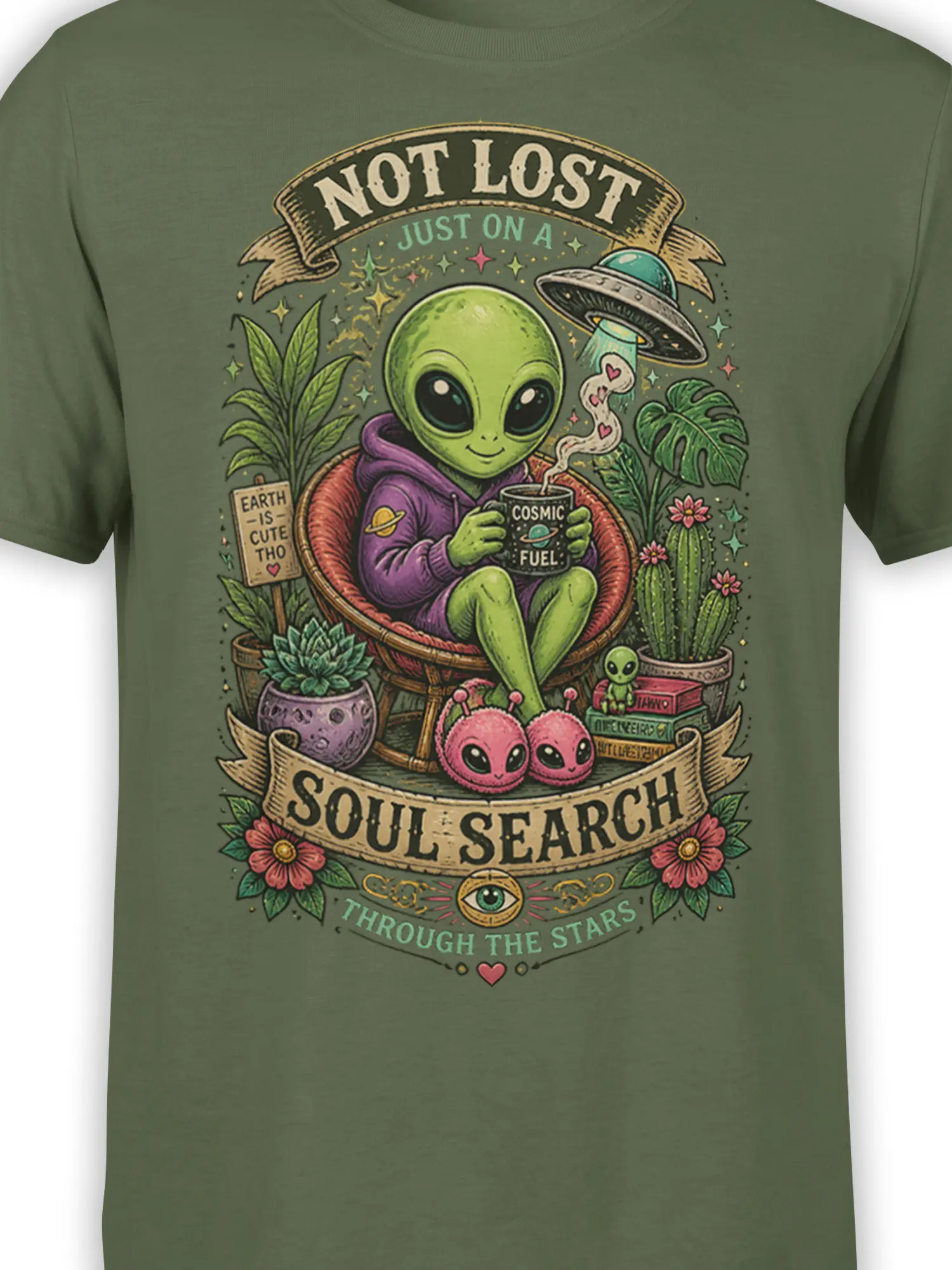 Close-up of green alien T-shirt artwork with cosmic fuel mug, plants, UFO, stars, and retro lettering
