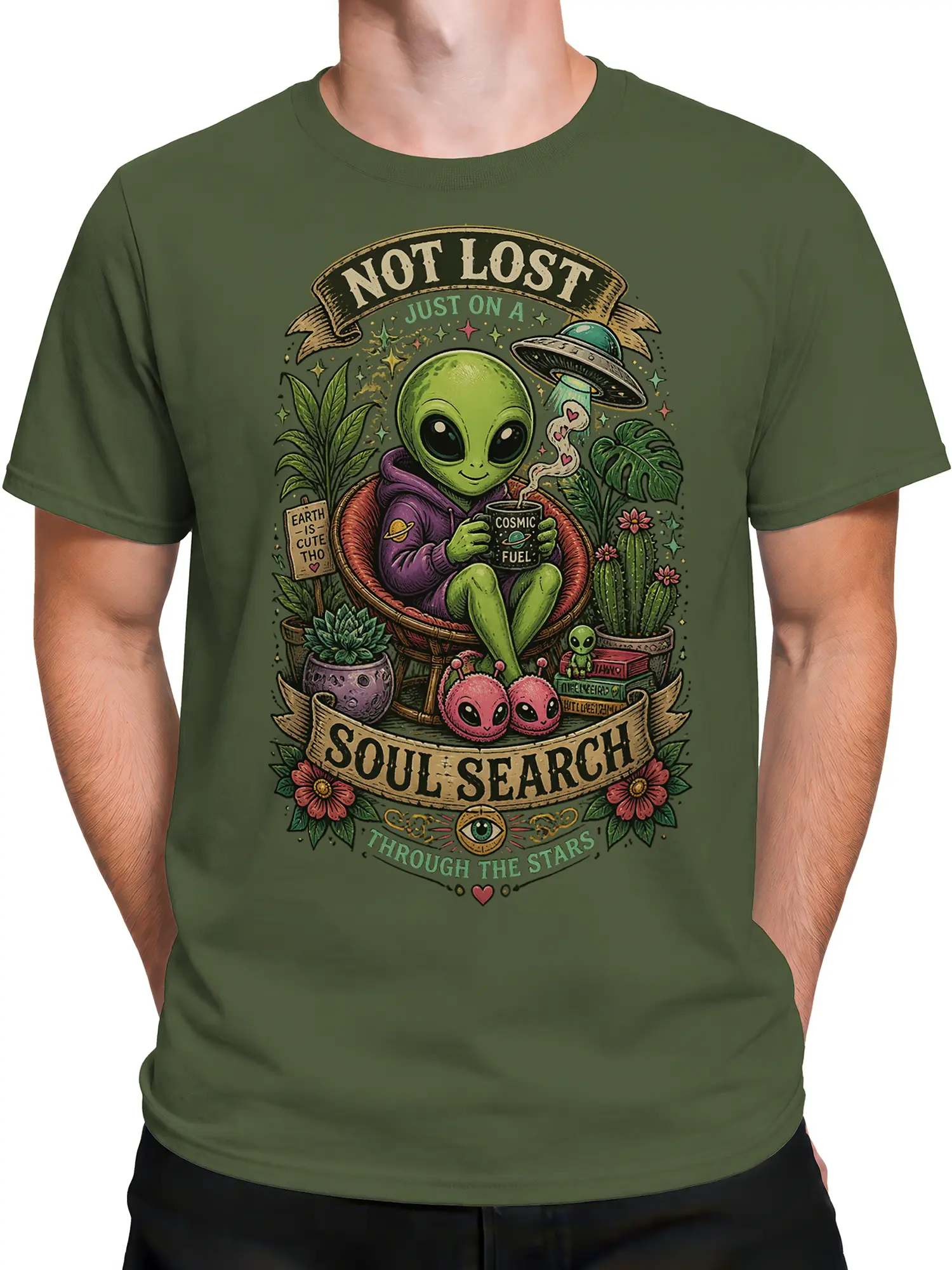 Male torso wearing a green alien T-shirt with a relaxed cosmic alien, coffee mug, plants, and stars