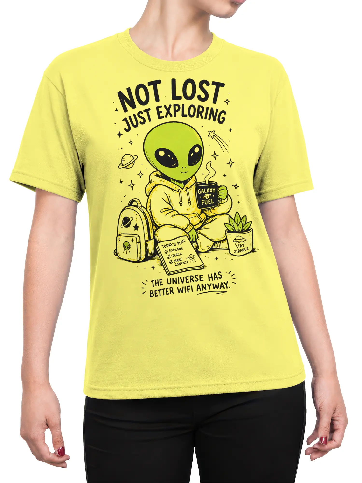 Female torso wearing a yellow alien explorer T-shirt with cosmic coffee, planets, stars, and playful space lettering