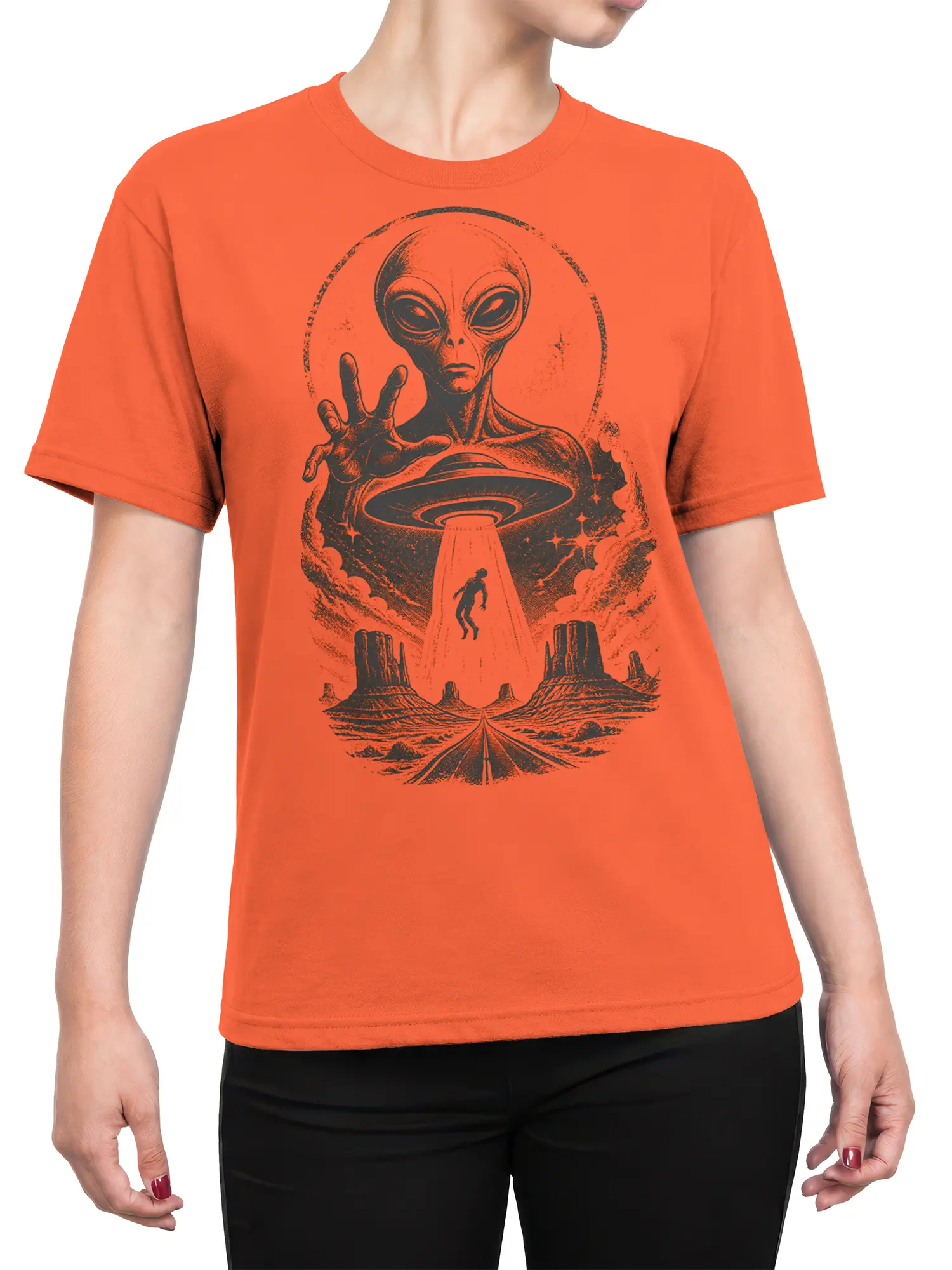 Female torso wearing an orange alien T-shirt with a flying saucer and desert abduction graphic