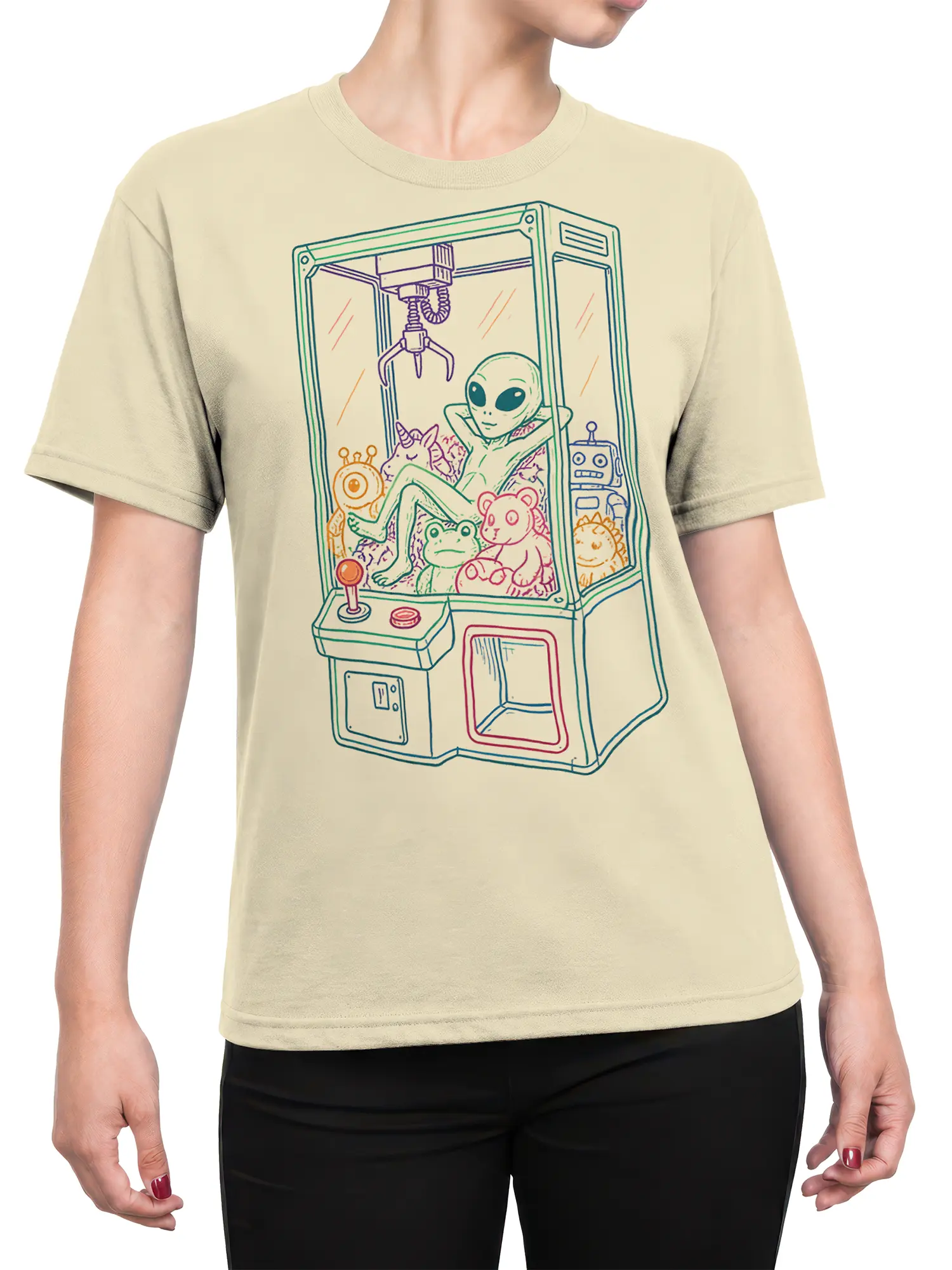 Female torso wearing a beige alien claw machine T-shirt with a colorful arcade scene and playful fantasy creatures