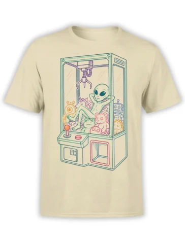 Beige alien claw machine T-shirt showing a relaxed green alien surrounded by a unicorn, frog, robot, and plush toys