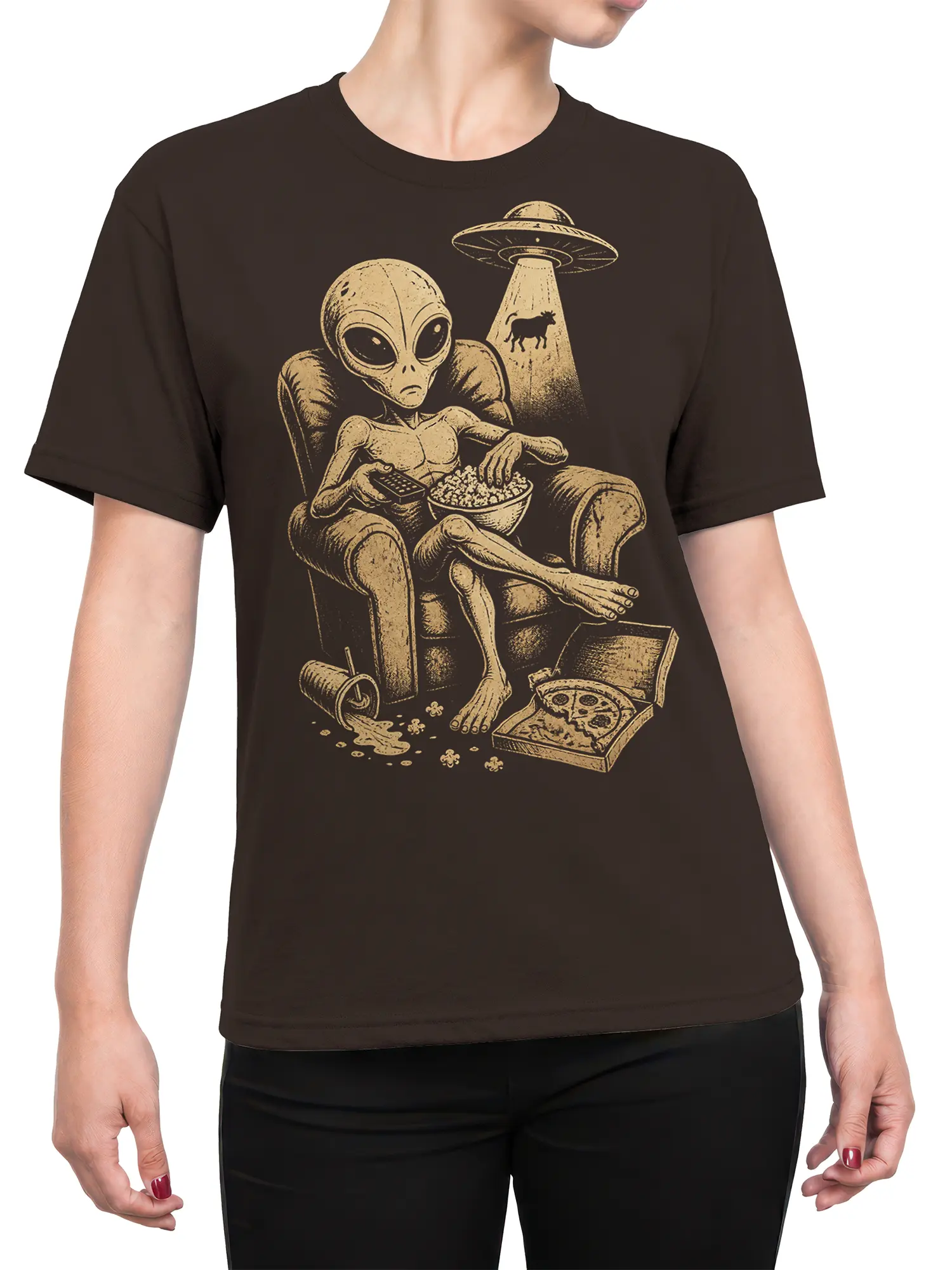 Female torso wearing a brown alien T-shirt with a vintage UFO, popcorn, pizza box, and relaxed extraterrestrial design