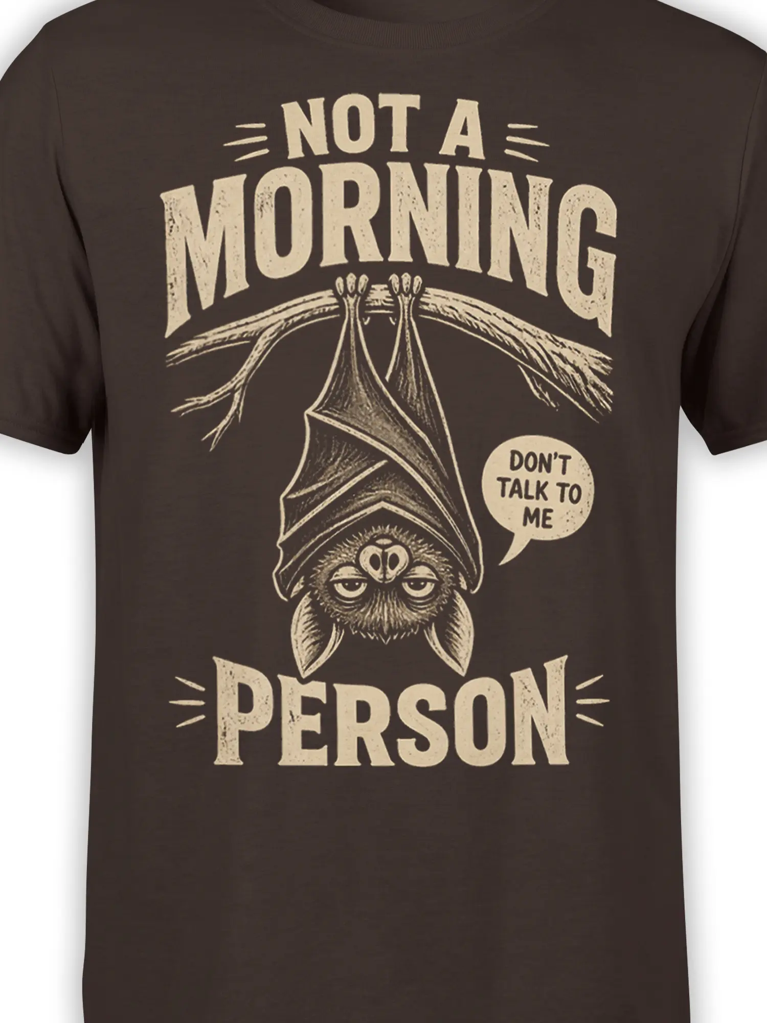 Close-up of sleepy bat artwork and distressed Not a Morning Person lettering on brown fabric