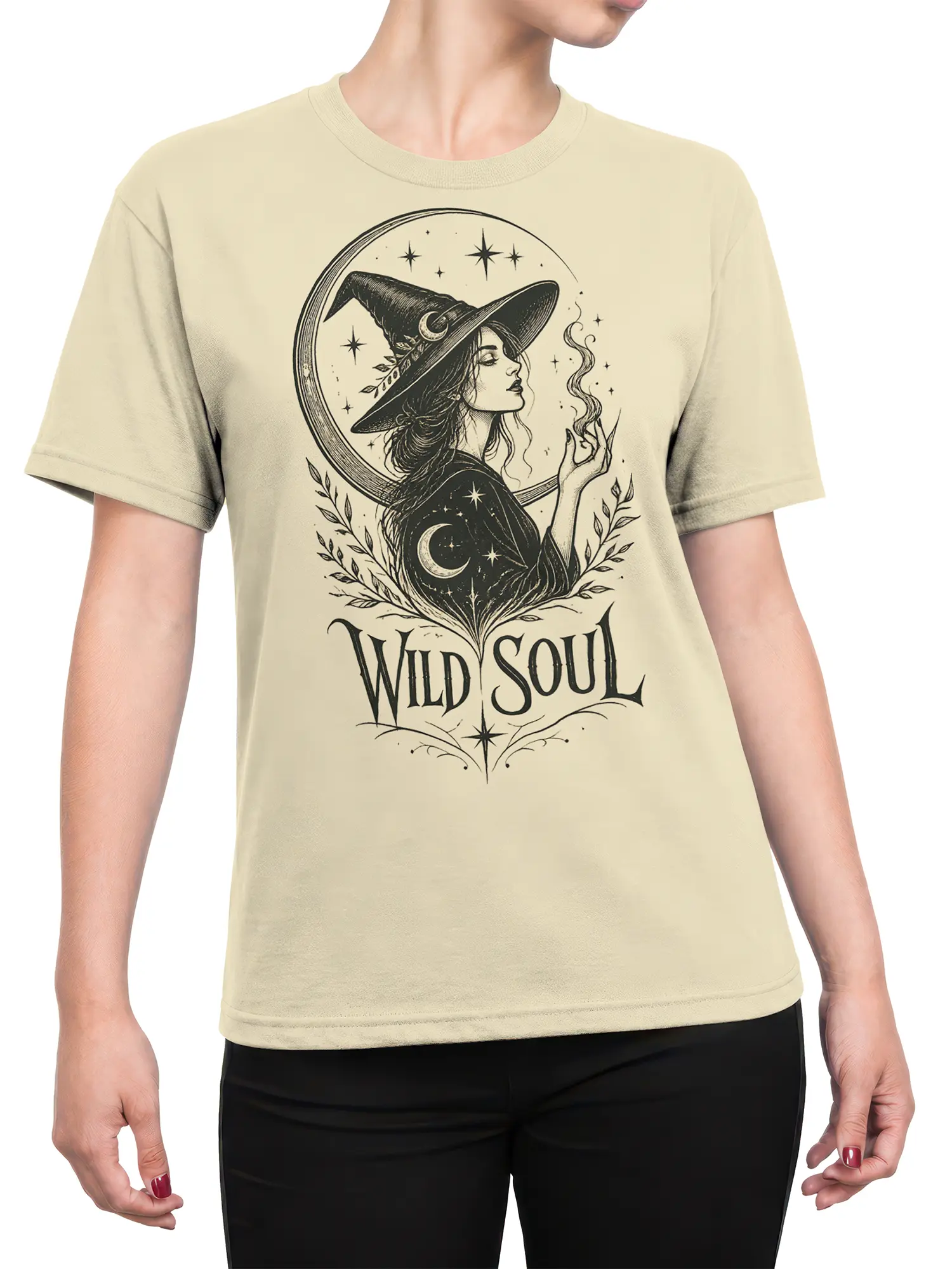 Female torso wearing a beige Wild Soul witch T-shirt with moon, stars, leafy details, and vintage fantasy artwork