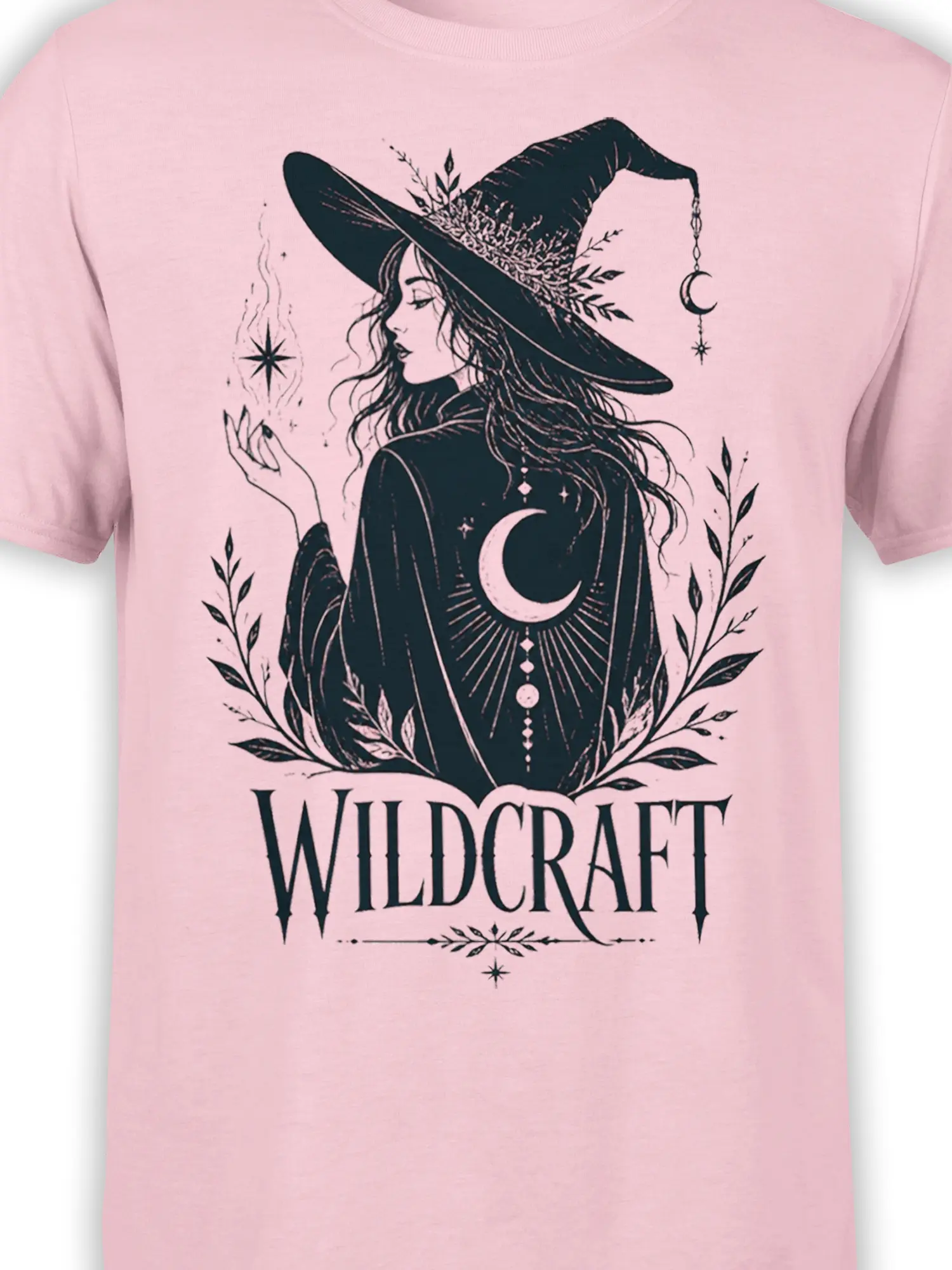 Close-up of pink witch T-shirt artwork with crescent moon, leafy branches, stars, and Wildcraft lettering