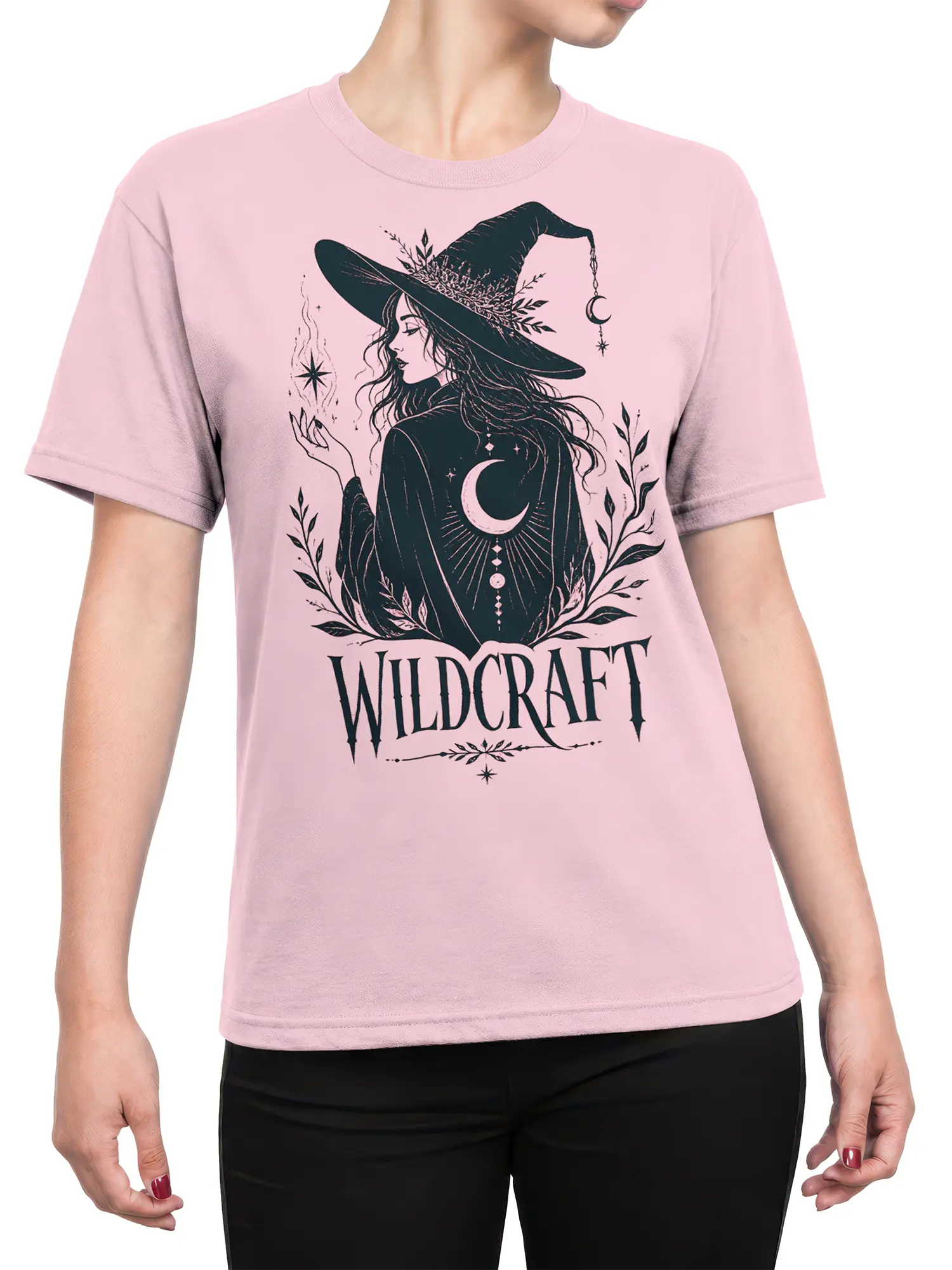 Female torso wearing a pink witch T-shirt with a crescent moon, botanical artwork, and Wildcraft lettering
