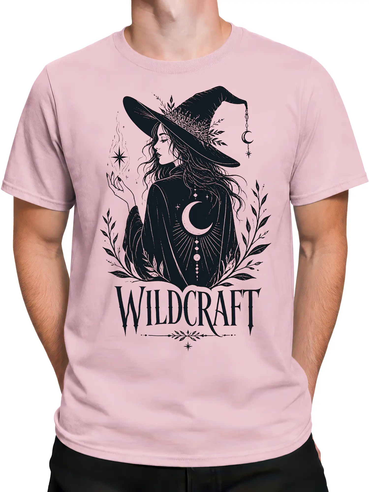 Male torso wearing a pink witch T-shirt with dark botanical artwork and bold Wildcraft lettering