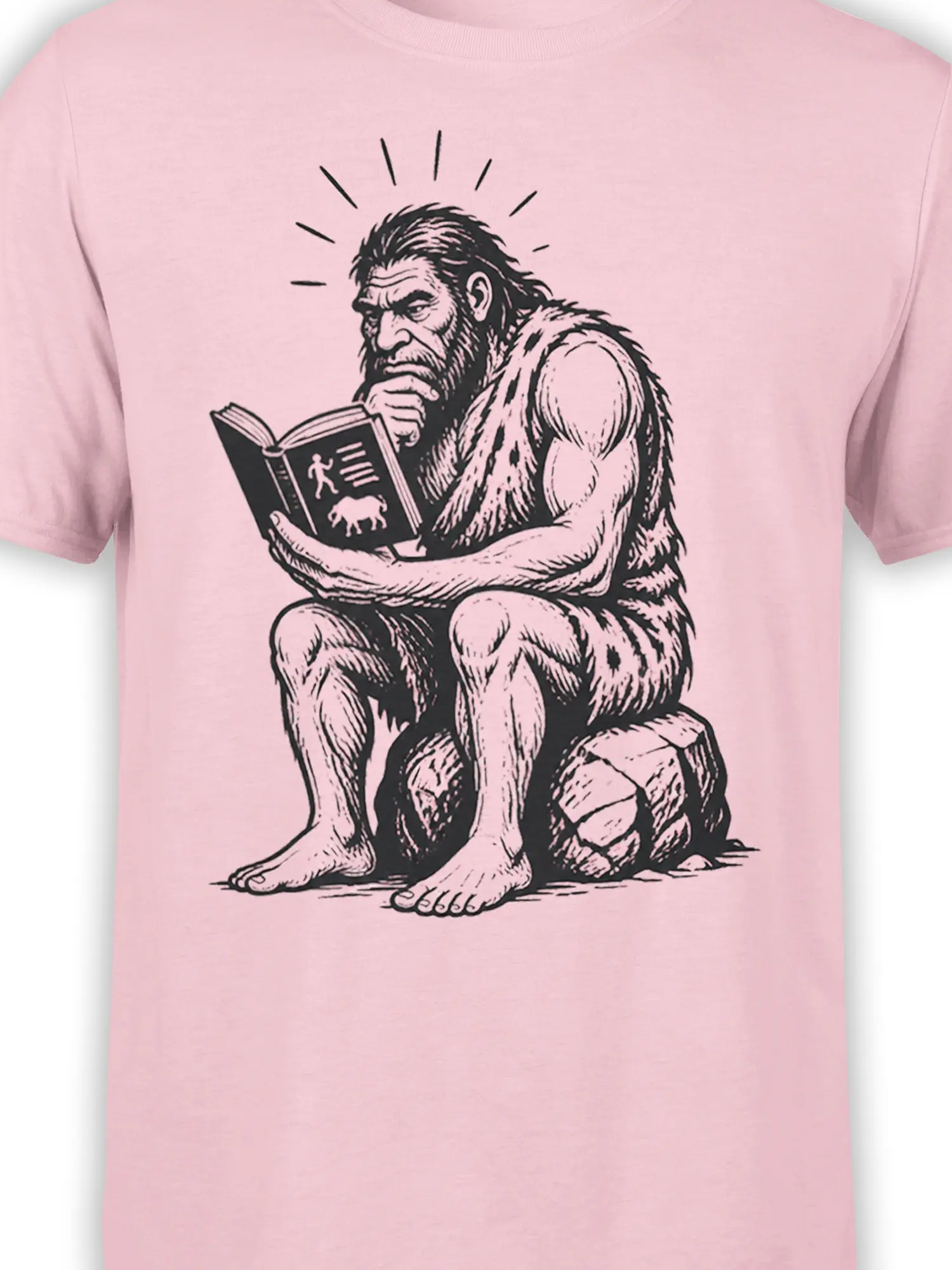 Close-up of the black caveman reader artwork and open book printed on a pink T-shirt